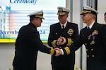 Cmdr. Robert Foster (left), incoming U.S. Aegis Ashore Missile Defense System Romania (USAAMDSRO) commanding officer, shakes hands with Cmdr. Matthew Iwanczuk (right), outgoing commanding officer, during a change of command ceremony on Naval Support Facility (NSF) Deveselu, Romania, Dec. 4, 2024.