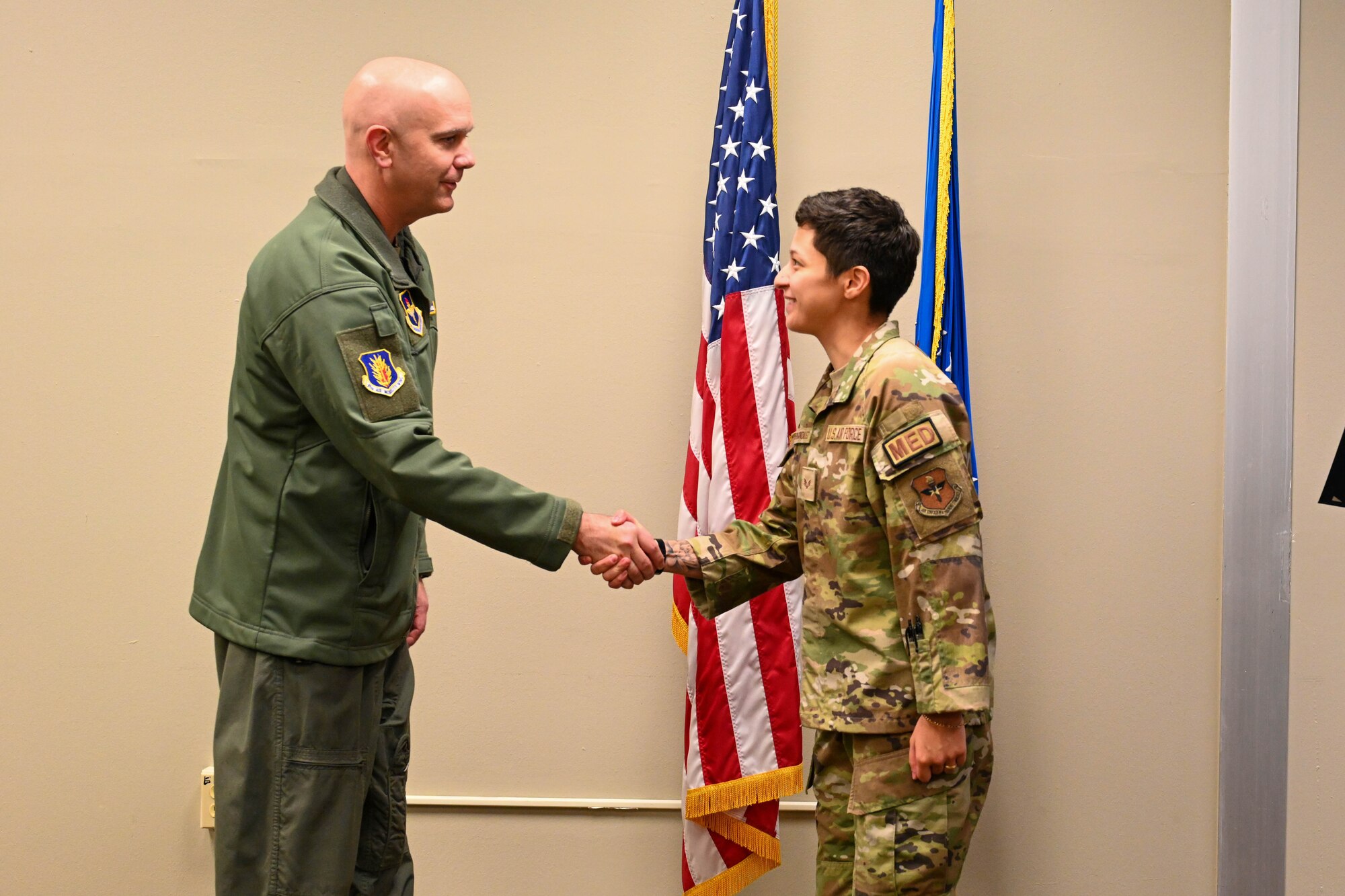 U.S. Air Force Col. Jeff Marshall, 97th Air Mobility Wing commander, shakes hands with Senior Airman Carapia Gonzalez, 97th Operational Medical Readiness Squadron aerospace medical technician, at Altus Air Force Base, Oklahoma, Dec. 2, 2024. Gonzalez is from Reno, Nevada. (U.S. Air Force photo by Senior Airman Miyah Gray)