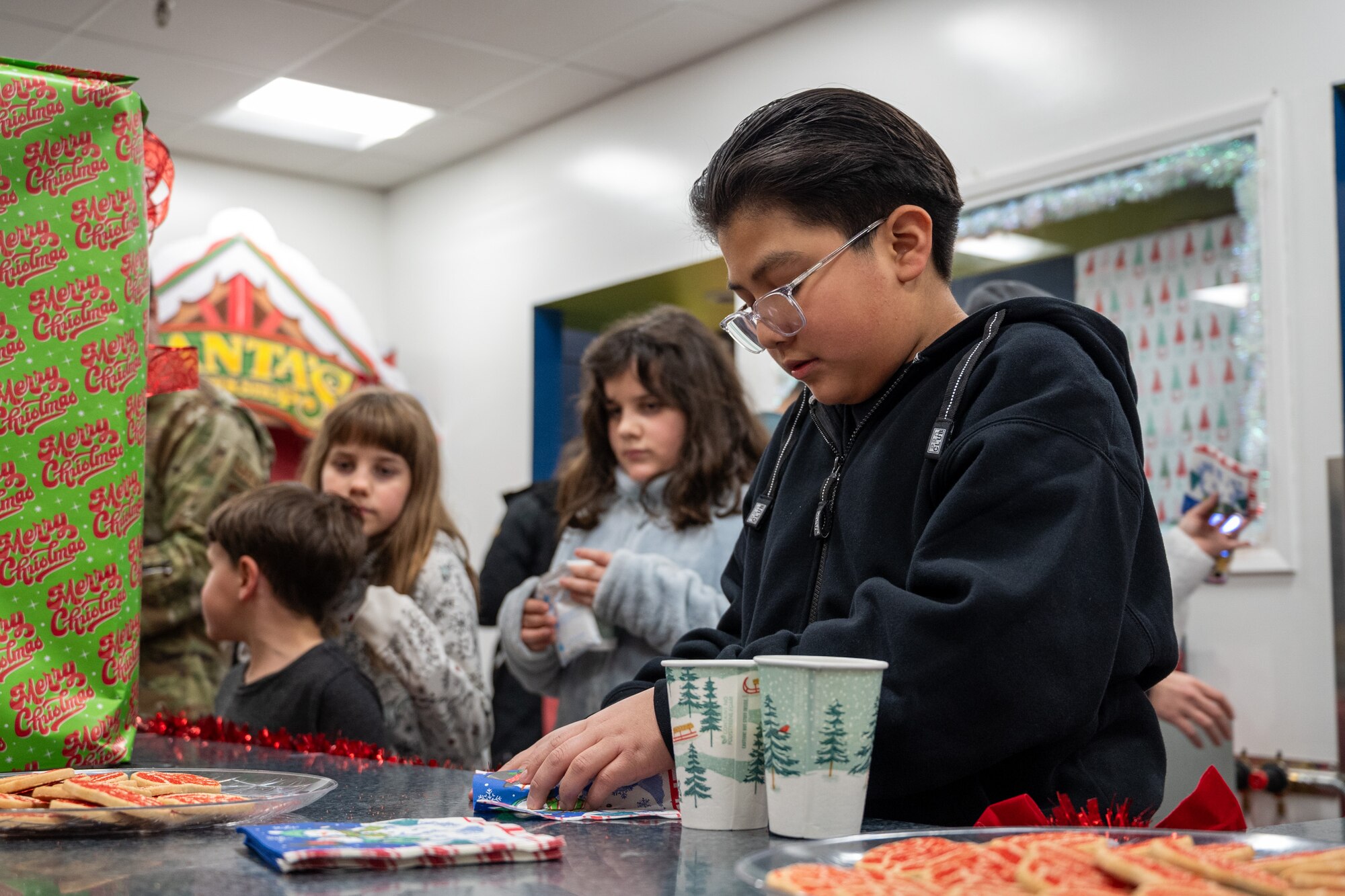 A child gathers their holiday cookies after the annual Team McChord holiday tree lighting ceremony at Joint Base Lewis-McChord, Washington, Dec. 5, 2024.