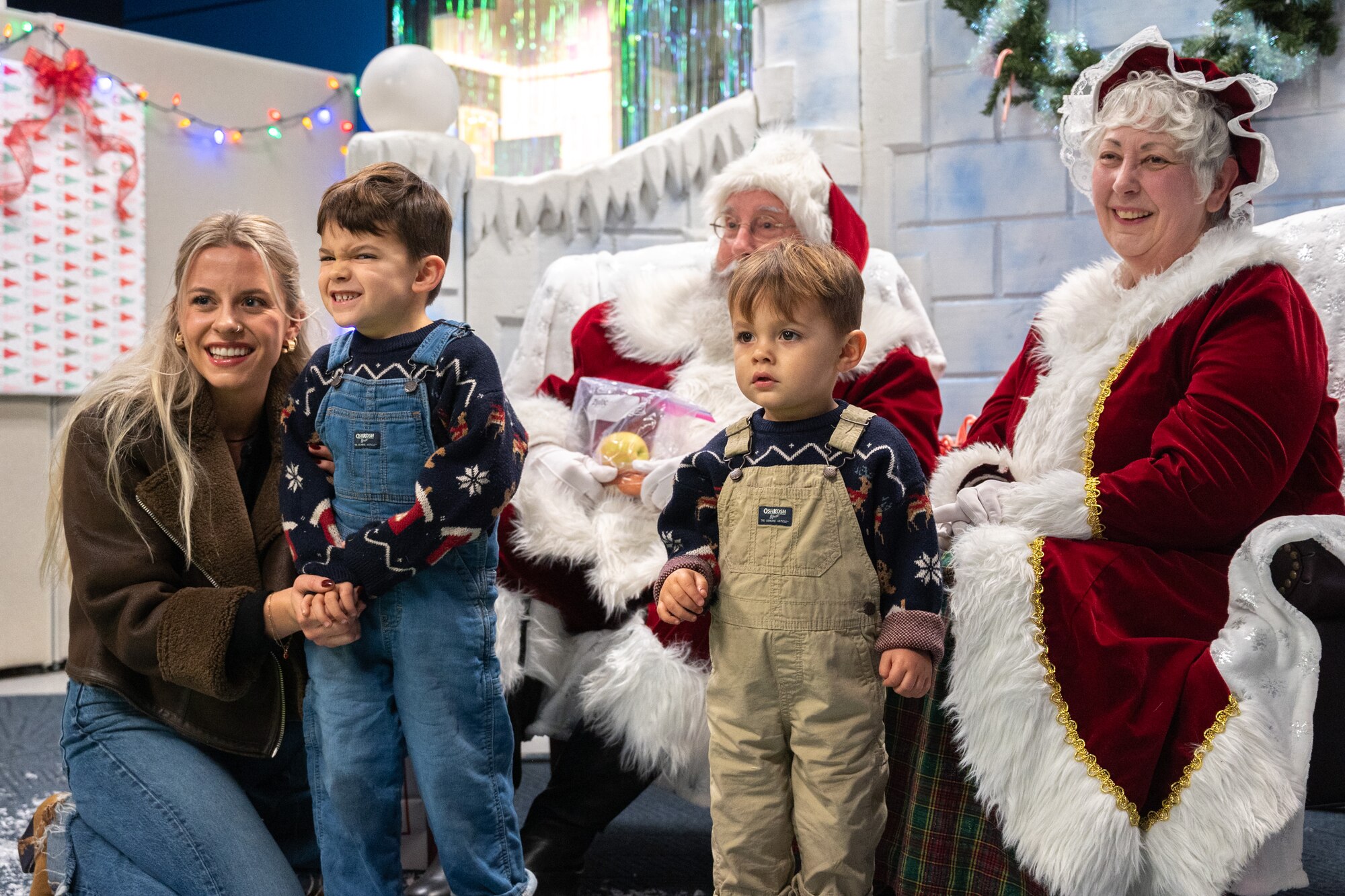 A mother and her children take a photo with Mr. and Mrs. Claus after the annual Team McChord holiday tree lighting ceremony at Joint Base Lewis-McChord, Washington, Dec. 5, 2024.