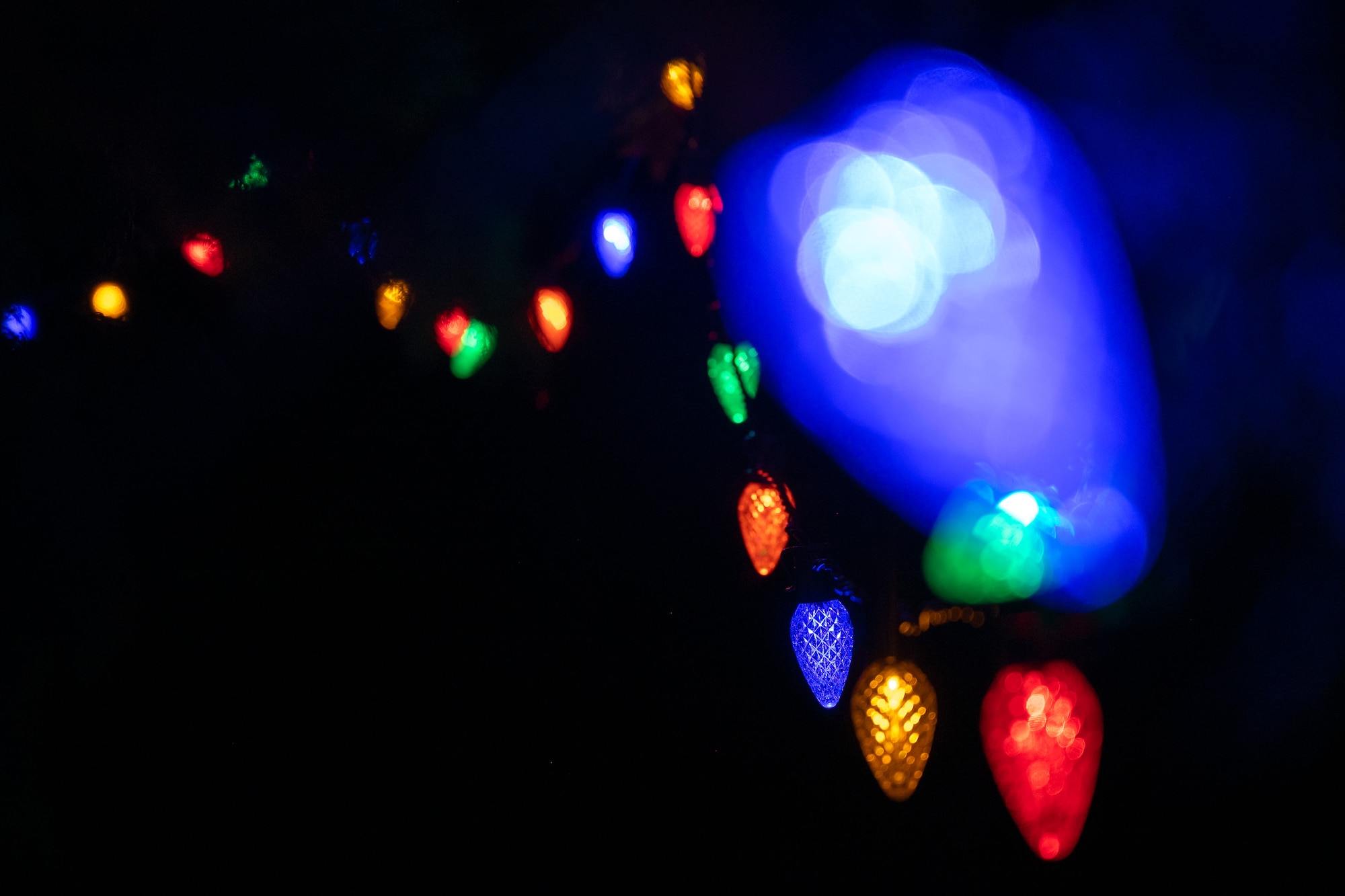 Blue, green, red, gold, and orange lights dangle from the McChord holiday tree after the annual Team McChord tree lighting ceremony Joint Base Lewis-McChord, Washington, Dec. 5, 2024.