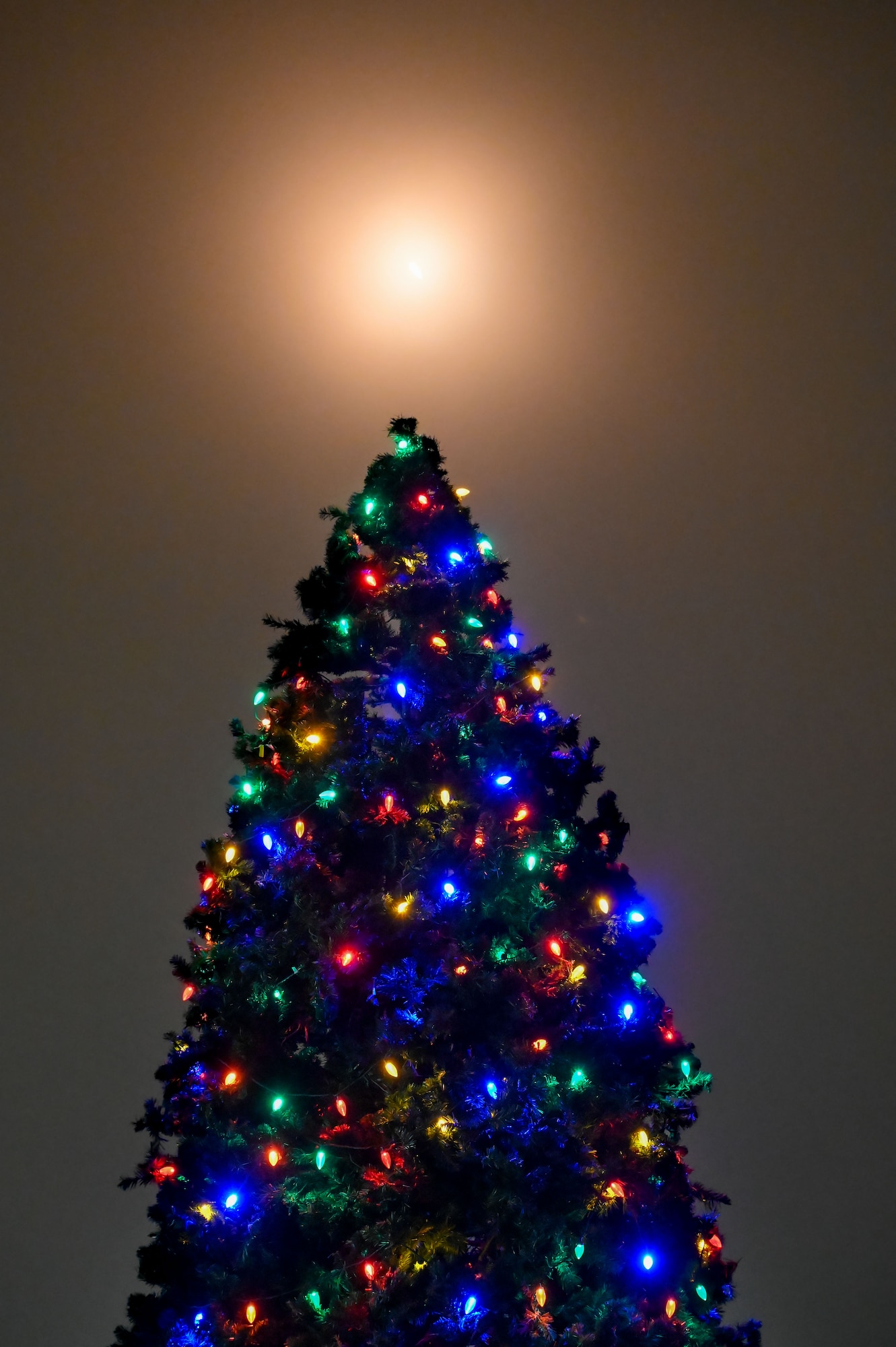 A rocket launches above a lit Christmas tree.