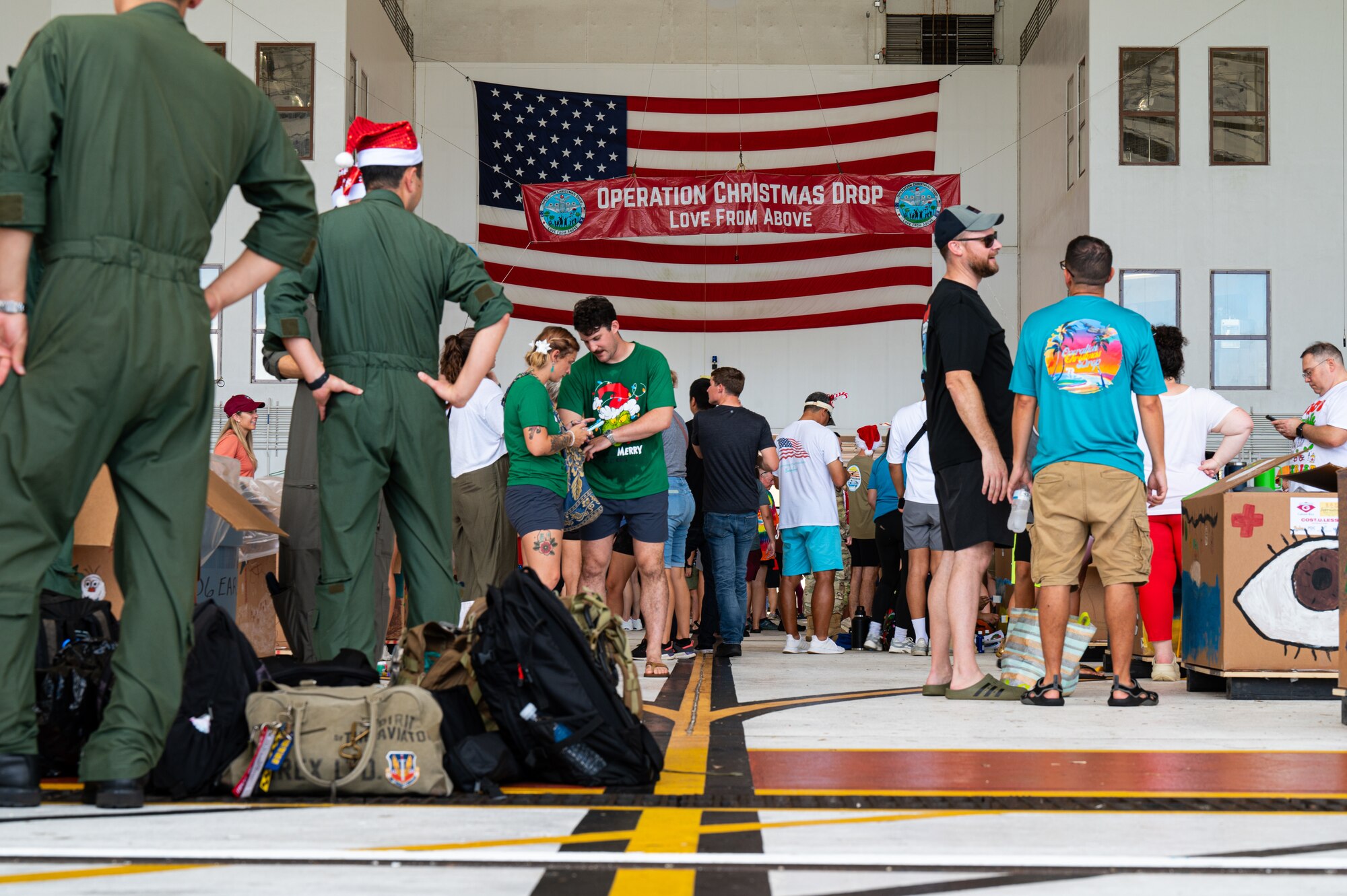 Service members and volunteers from different corners of the Pacific theater gathered in Hangar 5 to pack boxes with supplies, including canned goods, clothing, school items, toys and more Dec. 7.