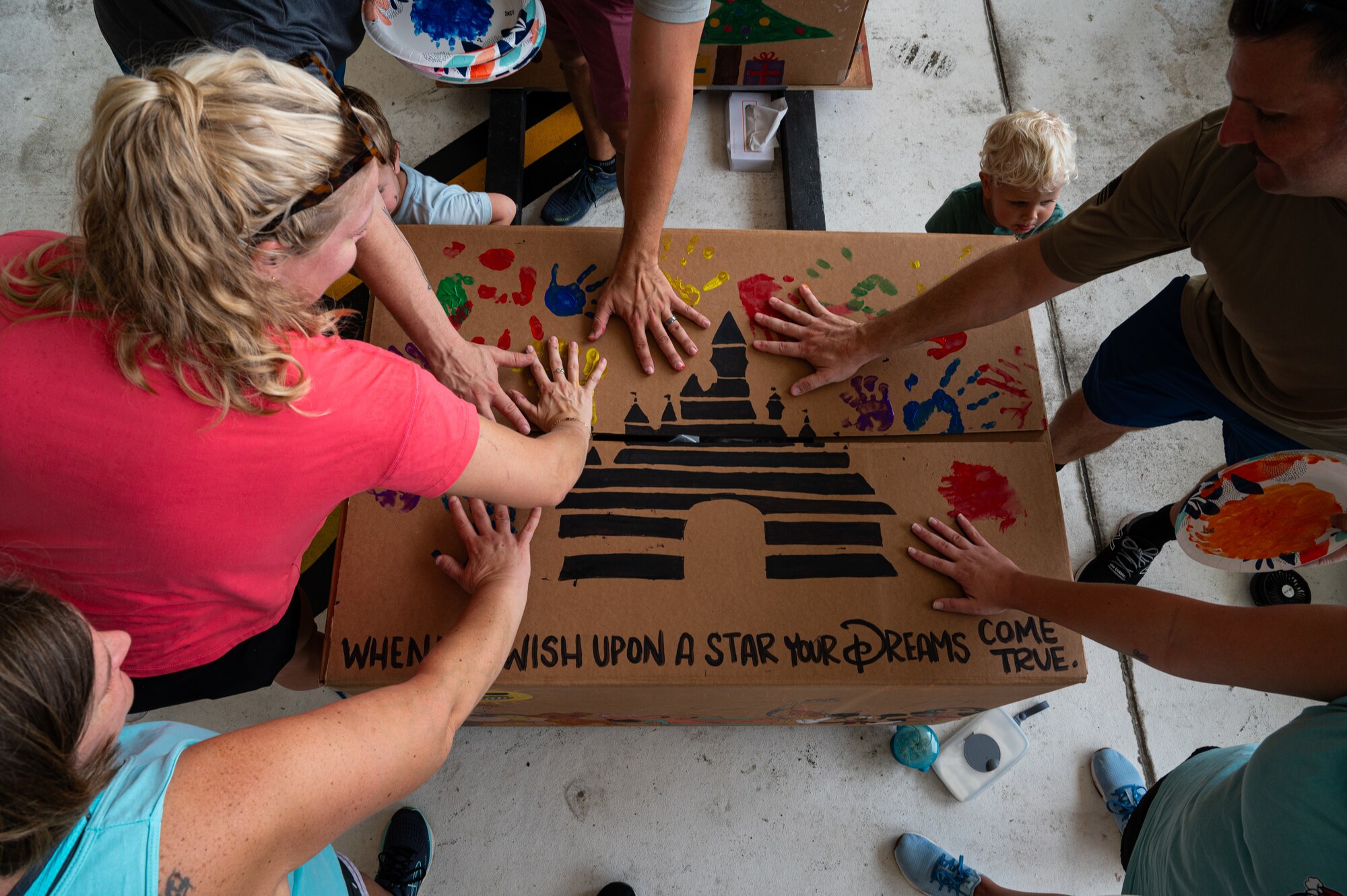 Service members and volunteers from different corners of the Pacific theater gathered in Hangar 5 to pack boxes with supplies, including canned goods, clothing, school items, toys and more Dec. 7.