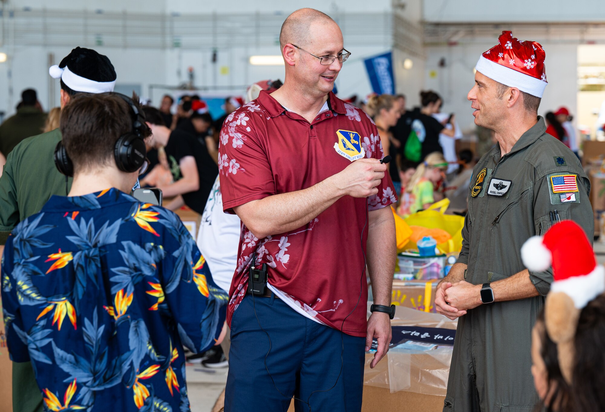 Service members and volunteers from different corners of the Pacific theater gathered in Hangar 5 to pack boxes with supplies, including canned goods, clothing, school items, toys and more Dec. 7.