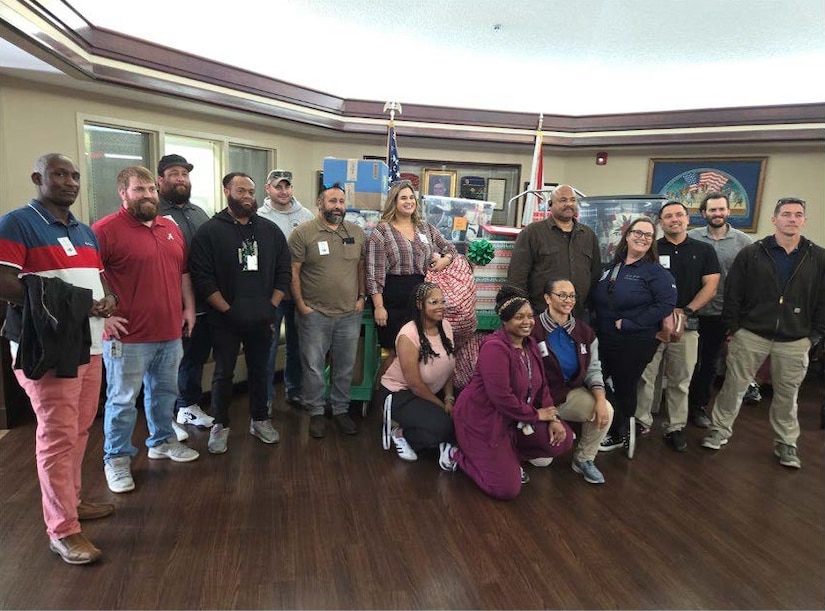 About 20 people pose for a photo in a lobby-type room.