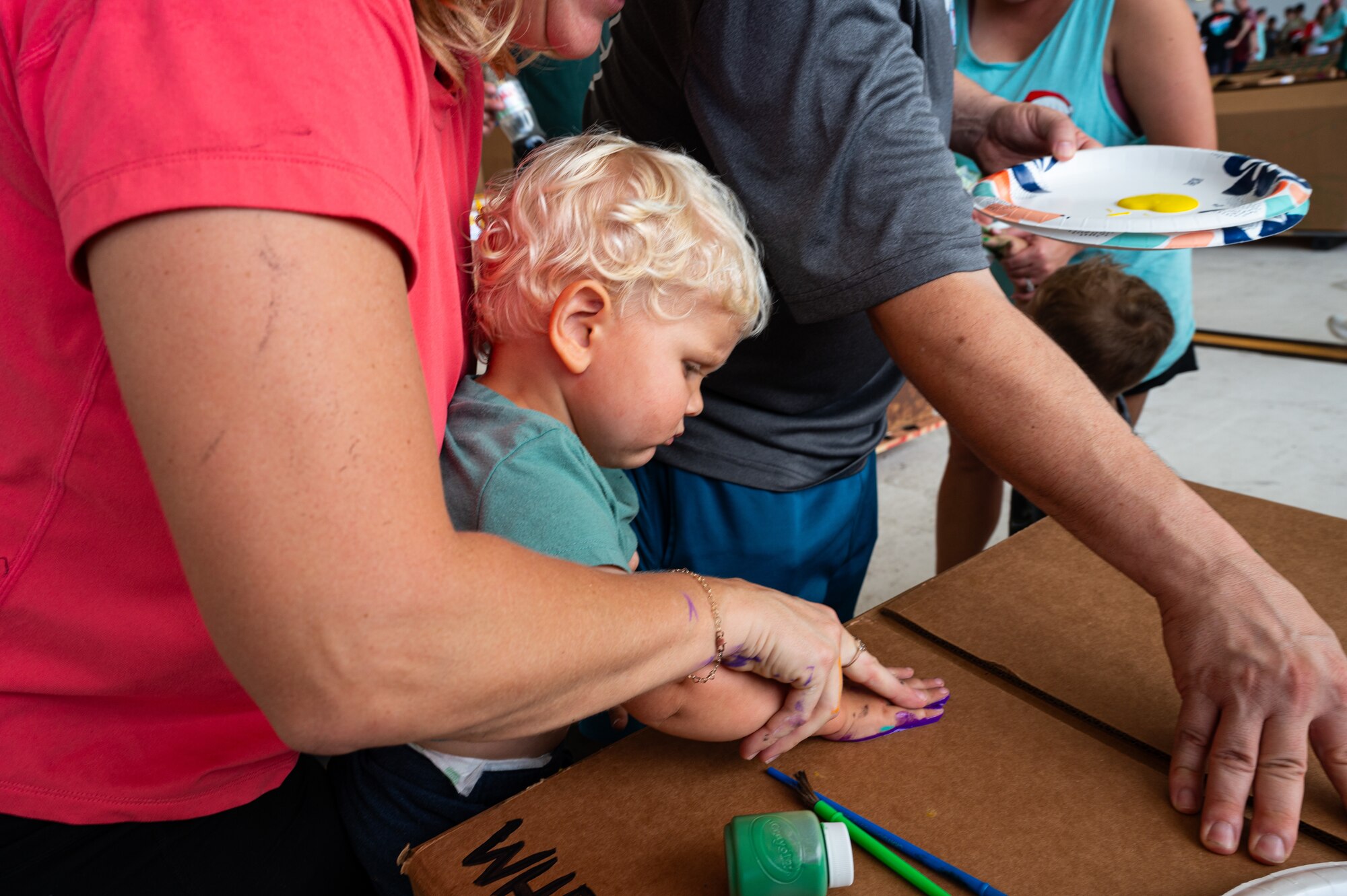 Service members and volunteers from different corners of the Pacific theater gathered in Hangar 5 to pack boxes with supplies, including canned goods, clothing, school items, toys and more Dec. 7.
