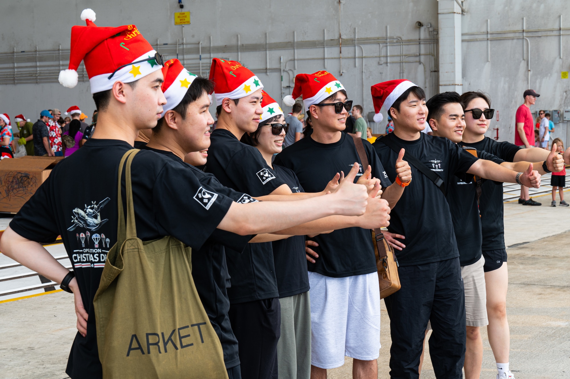 Service members and volunteers from different corners of the Pacific theater gathered in Hangar 5 to pack boxes with supplies, including canned goods, clothing, school items, toys and more Dec. 7.