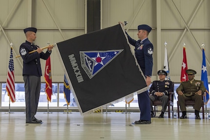 Two guardians unfurl a black flag with a delta symbol in the middle while inside.