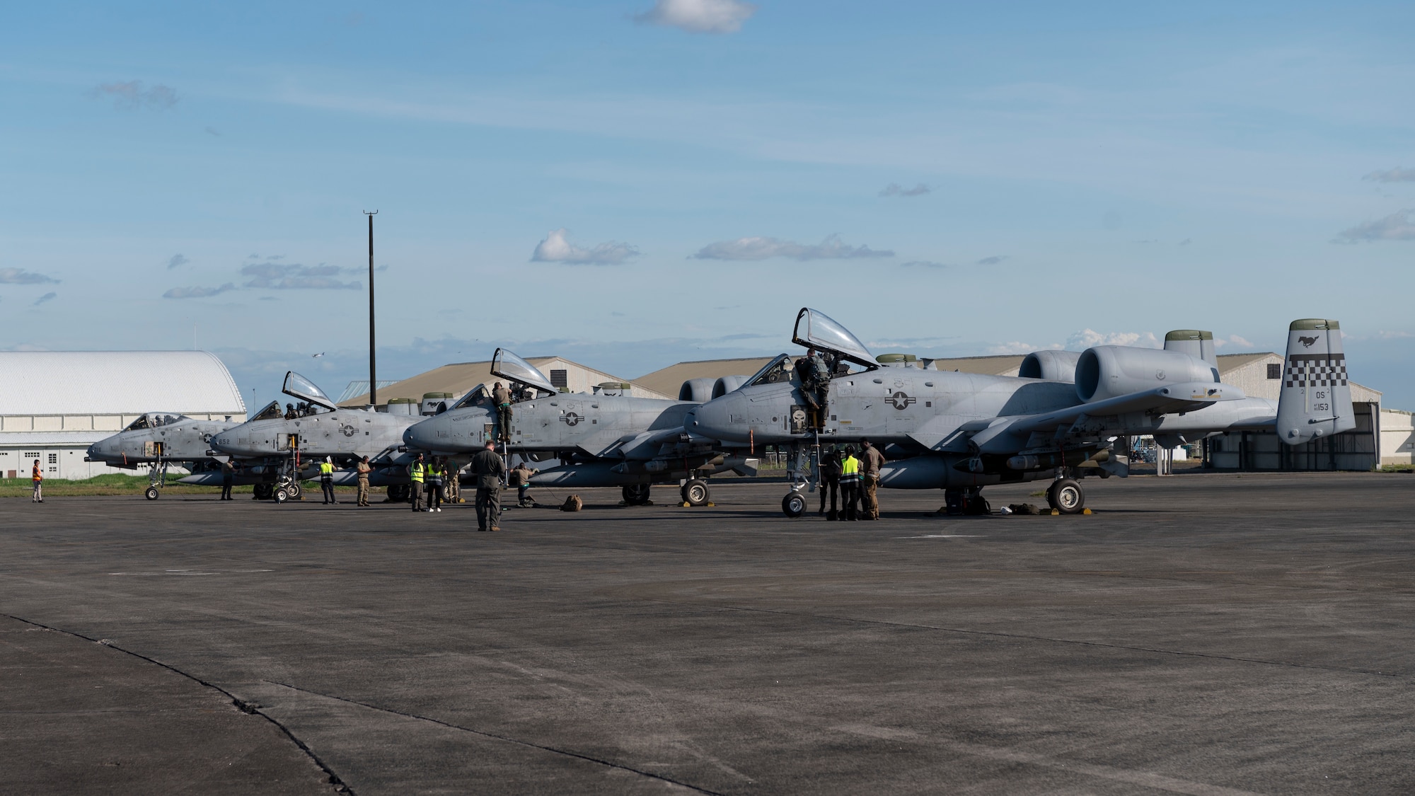 three fighter jets are parked neatly on a tarmac