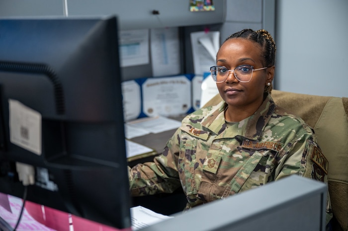 MSgt Mary Kyles sits behind a desk in an office.