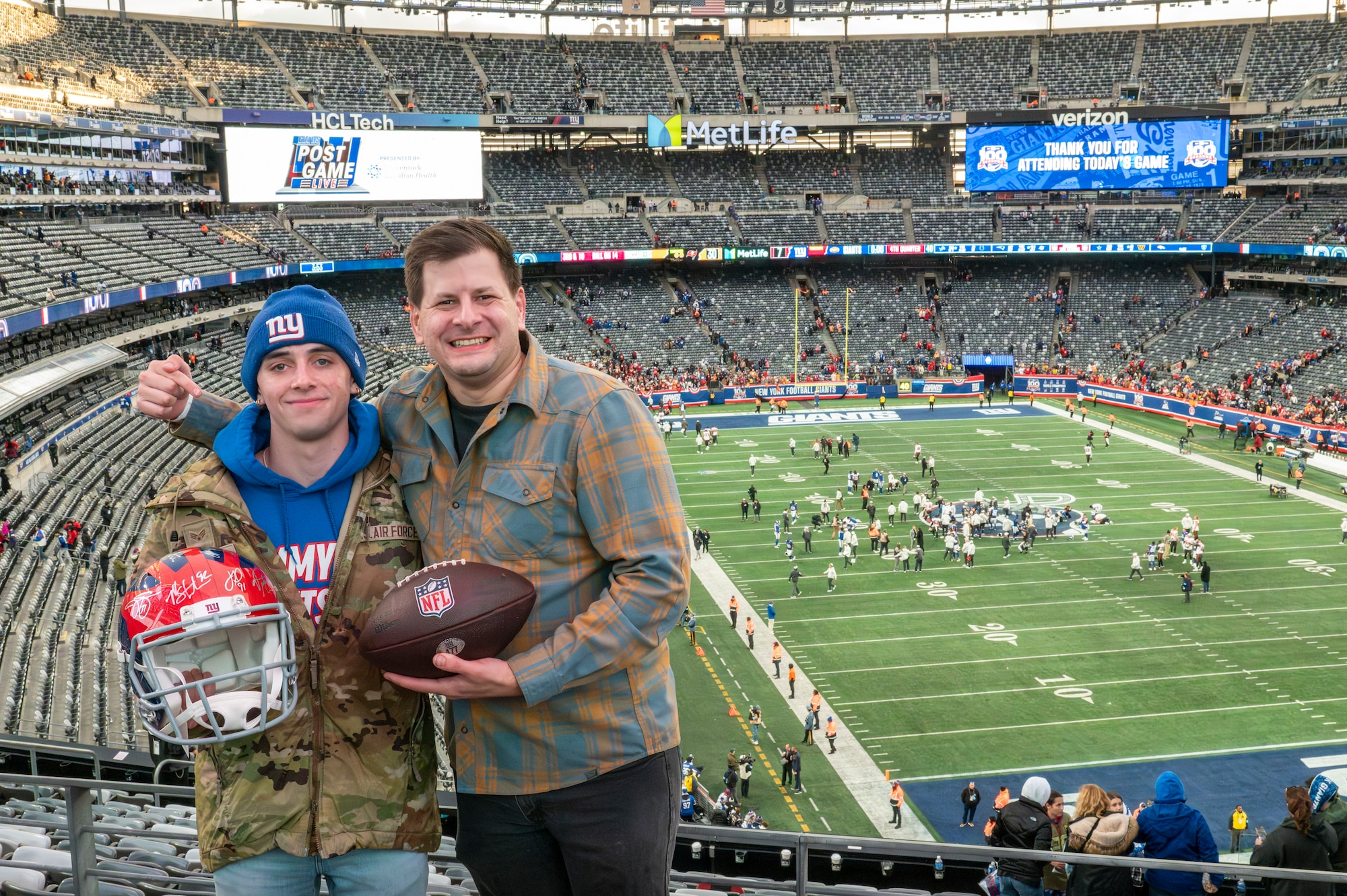 Senior Airman Christopher Megna, 514th Civil Engineer Squadron and Senior Master Sgt. Dakota Bordelon 514th Maintenance Squadron, pose for a photo during a Salute to Service New York Giants game at MetLife Stadium, N.J., November 17, 2024. Megna was selected to kick a field goal during half-time and successfully kicked two fields goals.