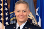 A photo of Air Force Gen. Timothy D. Haugh in front of flags.