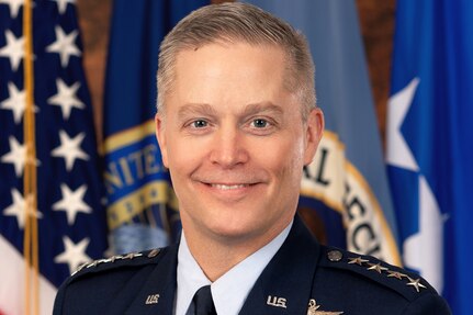 A photo of Air Force Gen. Timothy D. Haugh in front of flags.