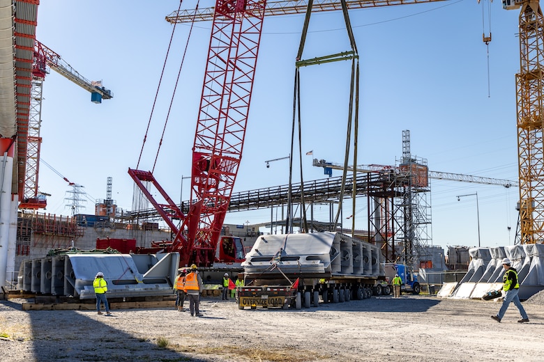 Shimmick Construction Company workers transfer a miter gate component at Chickamauga Lock near Chattanooga, Tennessee, Dec. 5, 2024. A total of 14 miter gate components are being delivered to the site each day from Dec.5-23, 2024. The Chickamauga Lock replacement project, managed by the U.S. Army Corps of Engineers Nashville District, includes designing a new 110-foot by 600-foot navigation lock to replace the current lock, which is necessary due to alkali-aggregate reaction, a chemical process that causes concrete to expand and crack, threatening the structural integrity of the lock.