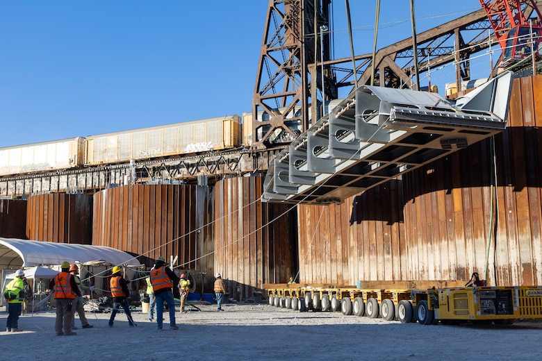 Shimmick Construction Company workers transfer a miter gate component at Chickamauga Lock near Chattanooga, Tennessee, Dec. 6, 2024. A total of 14 miter gate components are being delivered to the site each day from Dec.5-23, 2024. The Chickamauga Lock replacement project, managed by the U.S. Army Corps of Engineers Nashville District, includes designing a new 110-foot by 600-foot navigation lock to replace the current lock, which is necessary due to alkali-aggregate reaction, a chemical process that causes concrete to expand and crack, threatening the structural integrity of the lock.