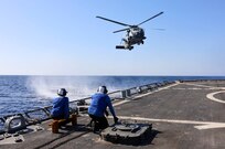 Sailors await the landing of an MH-60R attached to Helicopter Maritime Squadron 79 during flight quarters aboard the guided-missile destroyer USS Arleigh Burke (DDG 51).