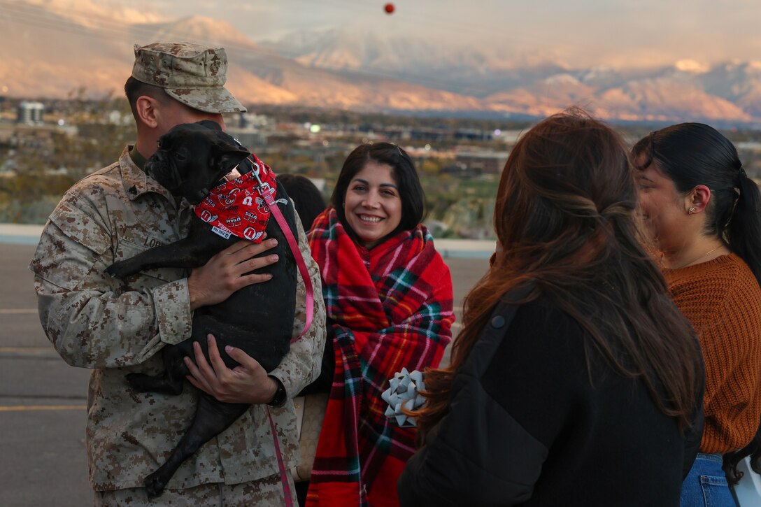 U.S. Marine Corps Cpl. Alexis Lopez with Fox Company, 2nd Battalion, 23d Marine Regiment, 4th Marine Division, holds his dog while his family comes to visit him before he leaves for the unit deployment program at Camp Williams, Utah, Nov. 3, 2024. The activation marks the beginning of an intensive period of training for 2nd Battalion, 23d Marines as they provide a total force solution in support of the UDP by aligning Marine Forces Reserve’s commitment to Marine Corps strategic objectives. This marks the first time since 2020 that an entire Reserve infantry battalion has activated to support the Unit Deployment Program. (U.S. Marine Corps photo by Cpl. Aaron TorresLemus)