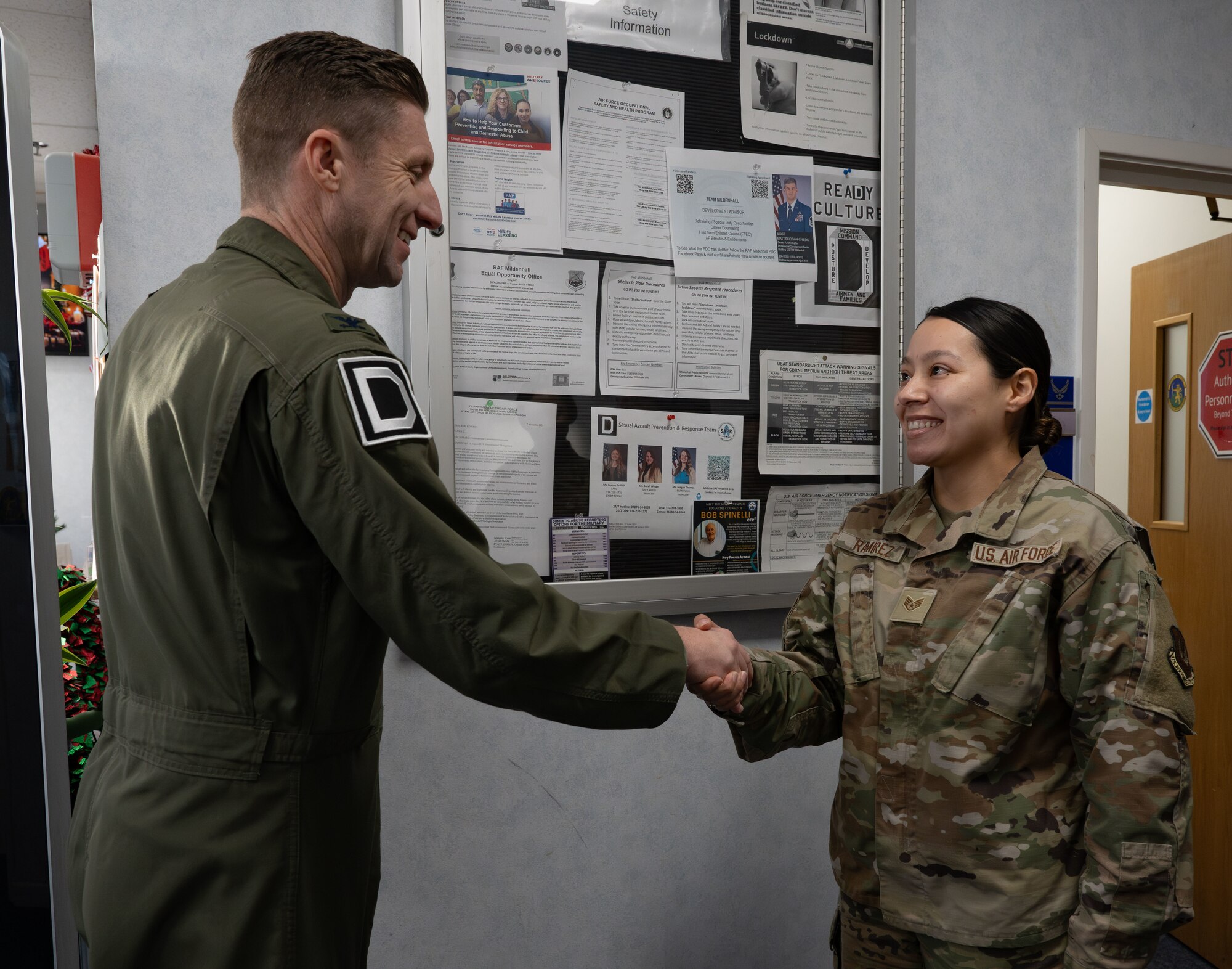 U.S. Air Force Col. Ryan Garlow, left, 100th Air Refueling Wing commander, coins Staff Sgt. Selena Ramirez, 100th Force Support Squadron noncommissioned officer in charge of official passports, at Royal Air Force Mildenhall, England, Dec. 6, 2024.
