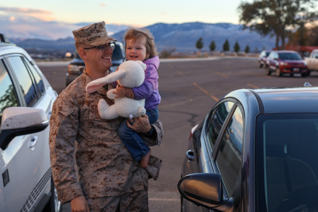 U.S. Marine Corps Cpl. Chaison Leavitt, machine gunner with Fox Company, 2nd Battalion, 23d Marine Regiment, 4th Marine Division, carries his daughter as his family comes to visit him before activating for the unit deployment program at Camp Williams, Utah, Nov. 3, 2024. The activation marks the beginning of an intensive period of training for 2nd Battalion, 23d Marines as they provide a total force solution in support of the UDP by aligning Marine Forces Reserve’s commitment to Marine Corps strategic objectives. This marks the first time since 2020 that an entire Reserve infantry battalion has activated to support the Unit Deployment Program. (U.S. Marine Corps photo by Cpl. Aaron TorresLemus)