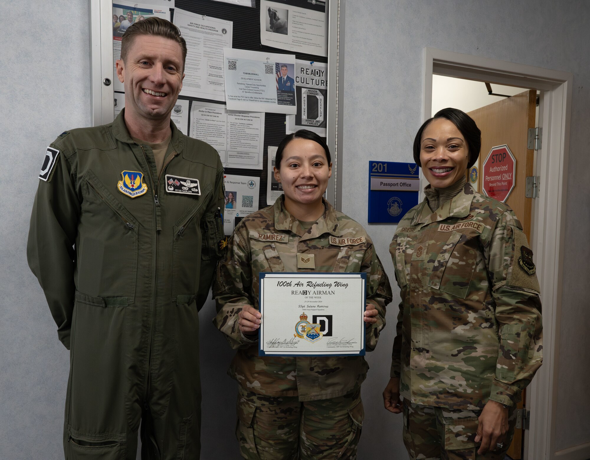 U.S. Air Force Col. Ryan Garlow, left, 100th Air Refueling Wing commander, Staff Sgt. Selena Ramirez, center, 100th Force Support Squadron noncommissioned officer in charge of official passports, and Chief Master Sgt. Tiffany Griego, 100th ARW command chief, pose for a photo at Royal Air Force Mildenhall, England, Dec. 6, 2024.