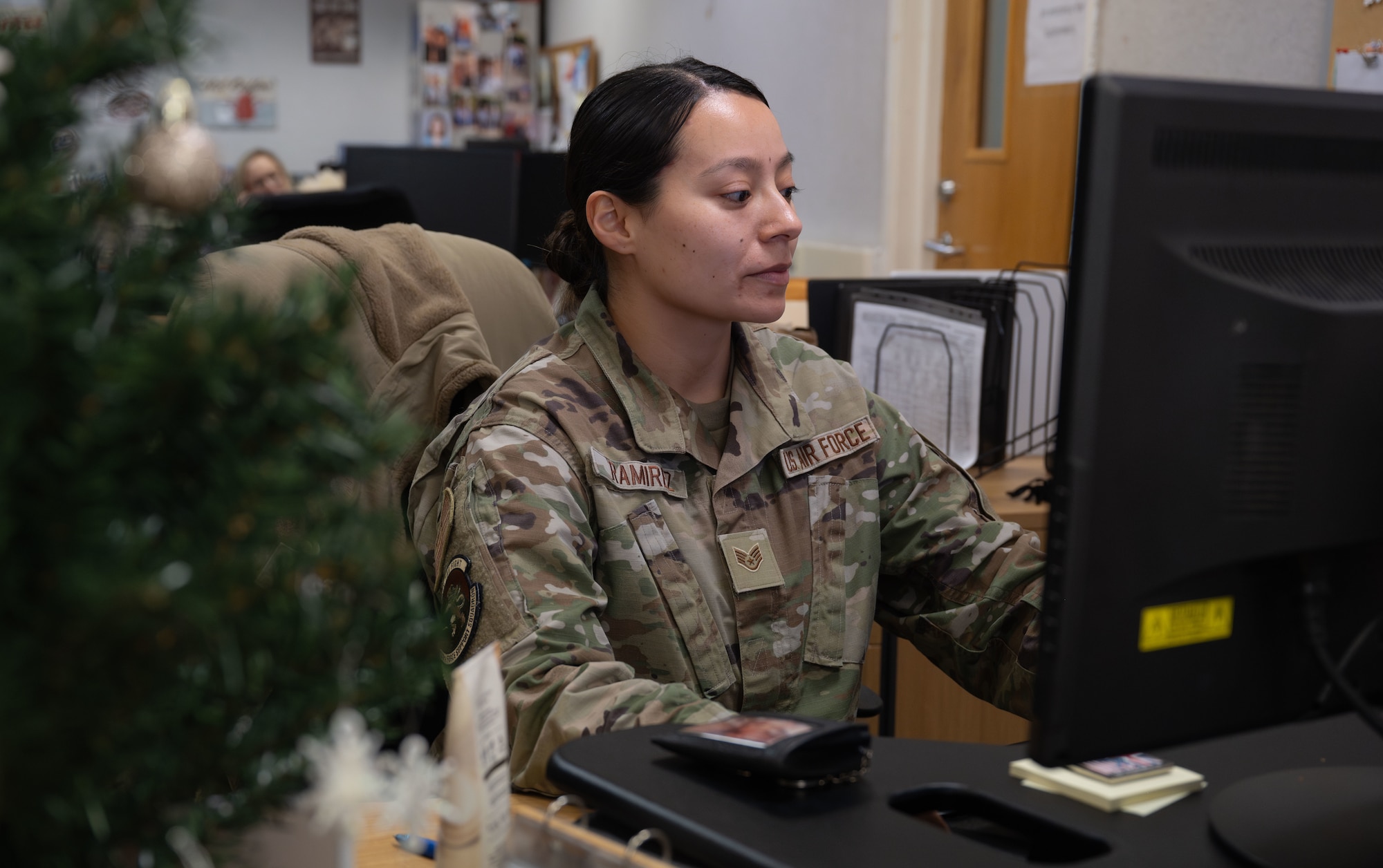 U.S. Air Force Staff Sgt. Selena Ramirez, 100th Force Support Squadron noncommissioned officer in charge of official passports, answers questions regarding visa requirements for traveling at Royal Air Force Mildenhall, England, Dec. 6, 2024.