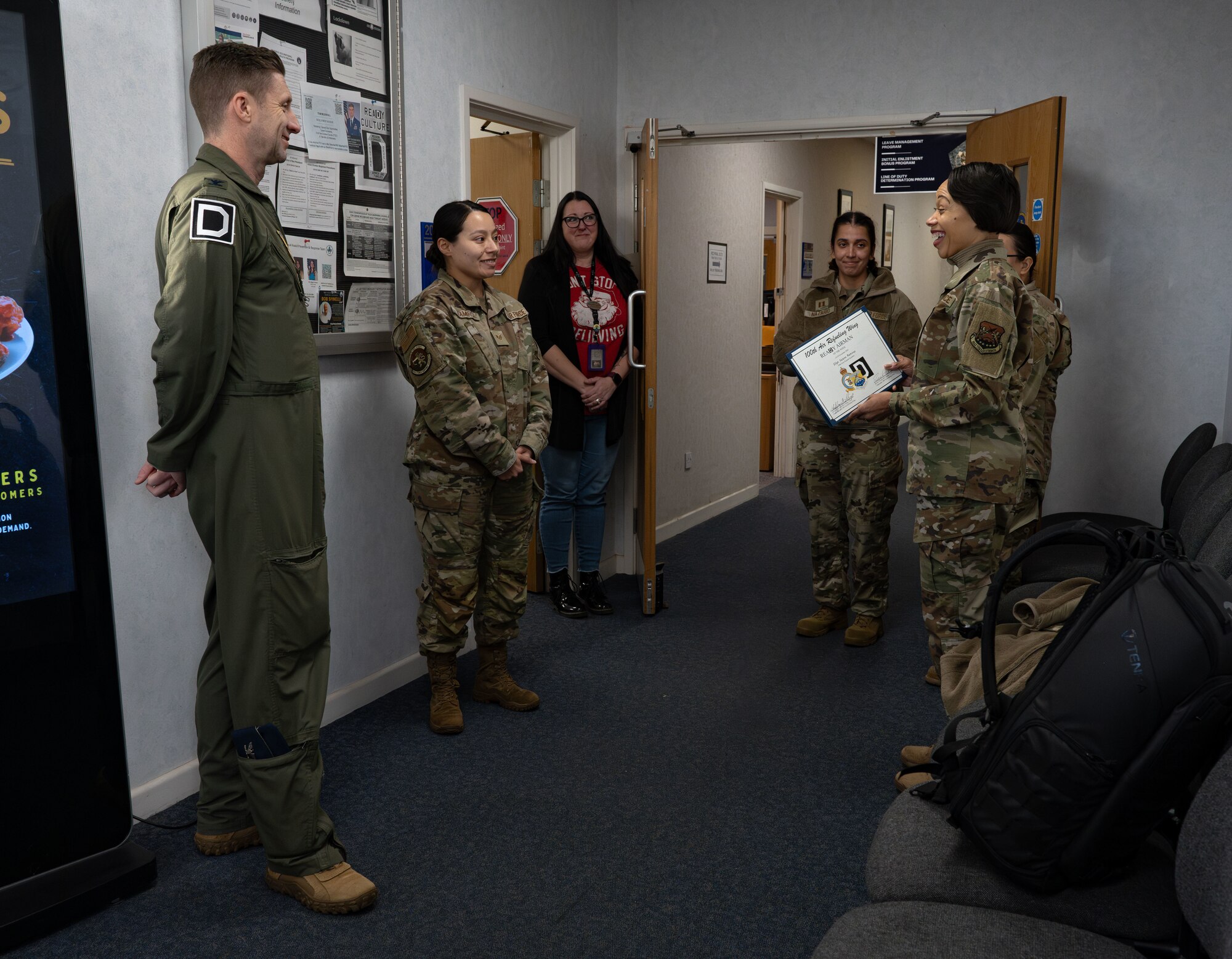 U.S. Air Force Chief Master Sgt. Tiffany Griego, right, 100th Air Refueling Wing command chief, and Col. Ryan Garlow, left, 100th ARW commander, award Staff Sgt. Selena Ramirez, 100th Force Support Squadron noncommissioned officer in charge of official passports, with the ReaDy Airman of the Week certificate at Royal Air Force Mildenhall, England, Dec. 6, 2024.