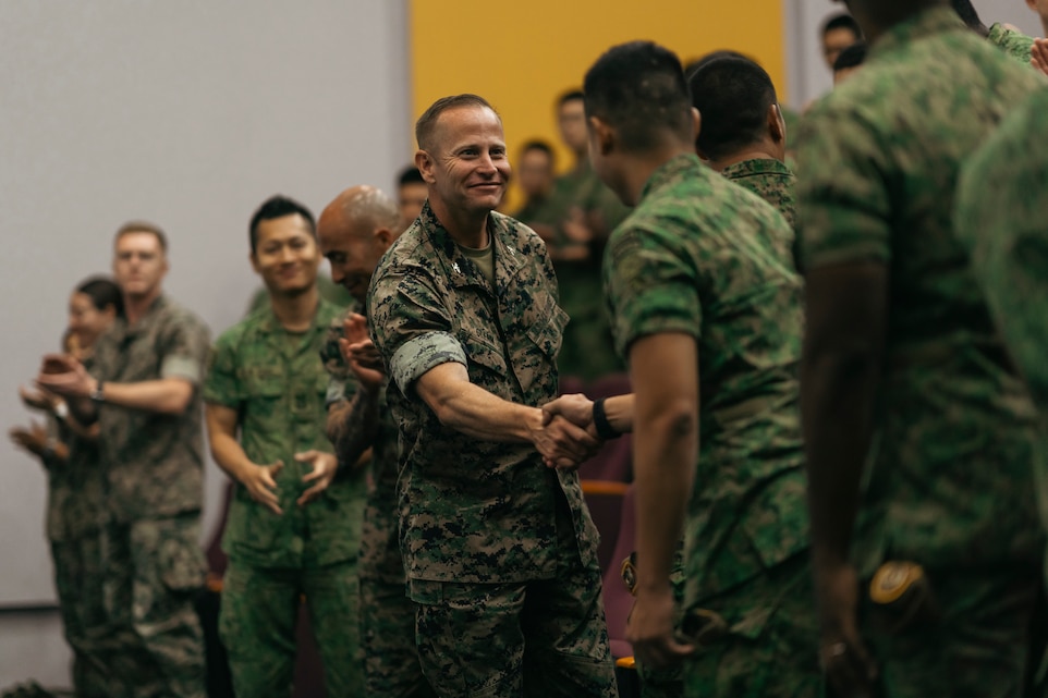 U.S. Marine Corps Col. Stuart Glenn, the commanding officer for Marine Rotational Force - Southeast Asia, I Marine Expeditionary Force, shakes hands with Singapore Guardsman Senior Lt. Col. Michael Enriquez, the commanding officer for 7th Singapore Infantry Brigade, during the opening ceremony for Valiant Mark 24 on Bedok Camp, Singapore, Dec. 9, 2024. Valiant Mark is an annual, bilateral training exercise conducted between the Singapore Armed Forces and I MEF, designed to enhance interoperability, improve combined arms and amphibious warfighting skills, and strengthen military-to-military relationships. MRF-SEA is a rotational unit derived from elements of I MEF executing a U.S. Marine Corps Forces, Pacific operational model that involves training events and exchanges with partner military subject matter experts, promotes security goals with Allied and partner nations, and ensures a persistent I MEF stand-in presence west of the International Date Line. (U.S. Marine Corps photo by Sgt. Shaina Jupiter)