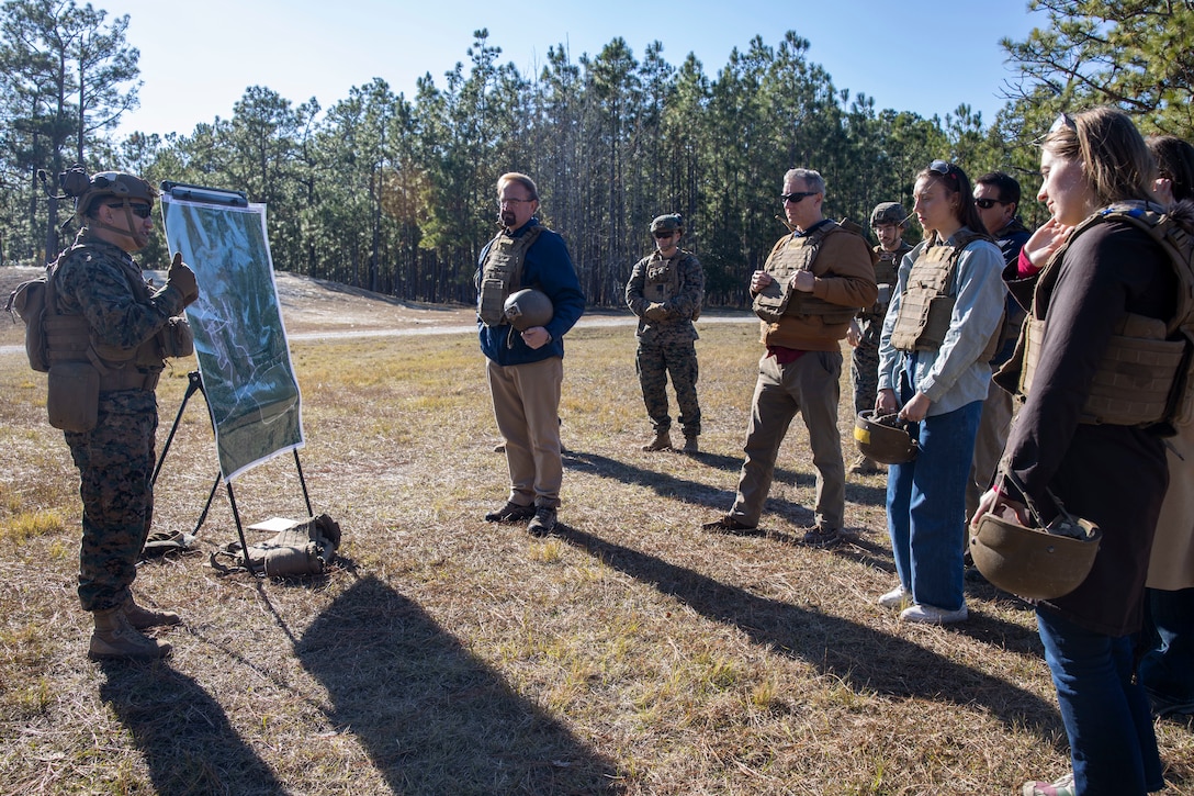 U.S. Marine Corps Master Sgt. Jose Portillo, left, operations chief with Advance Infantry Battalion, School of Infantry East Training Command, gives a scheme of maneuver brief during a tour at Marine Corps Base Camp Lejeune, North Carolina, Dec. 2, 2024. The Congressional Delegation (CODEL) was a bi-partisan visit consisting of House Appropriations Subcommittee on Defense (HAC-D) representatives who learned more about II MEF operations, capabilities and address issues related to DoD appropriations in North Carolina. (U.S. Marine Corps photo by Sgt. Jacquilyn Davis)