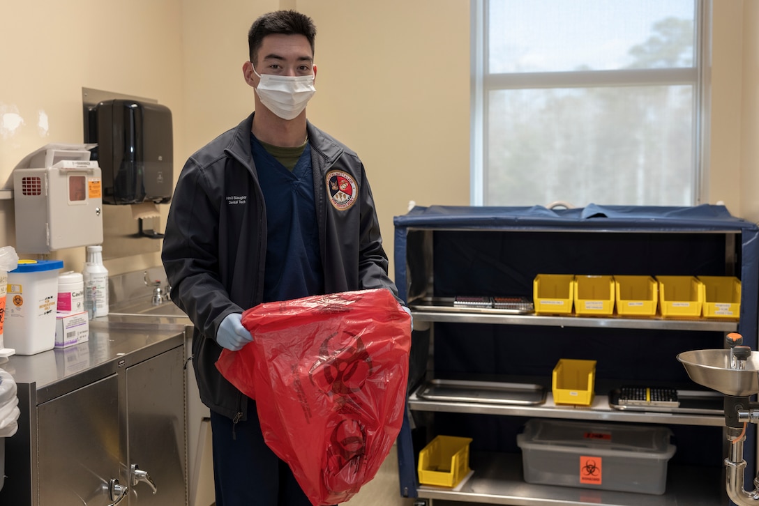 U.S. Navy Hospital Corpsman 3rd Class Cody Slaughter, a dental assistant with 2nd Dental Battalion, 2nd Marine Logistics Group, and a native of Abilene, Texas, opens biohazard bags on Camp Lejeune, North Carolina, Dec. 5, 2024. Slaughter was selected as warrior of the week for his dedication, leadership and work ethic that his command says sets him apart from his peers, ensuring mission success. When asked about his favorite part of his job, Slaughter said, “I think my favorite part of my job is interacting with the patients. It is rewarding to see someone who wasn’t confident in their smile, get up and look in the mirror after an operation and smile proudly.” Each week, 2nd MLG recognizes one outstanding Marine or Sailor that goes above and beyond in their duties and embodies the qualities of an outstanding service member. (U.S. Marine Corps photo by Cpl. Jessica J. Mazzamuto)