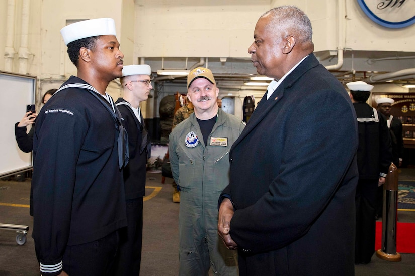 Secretary of Defense Lloyd J. Austin III speaks with a sailor.