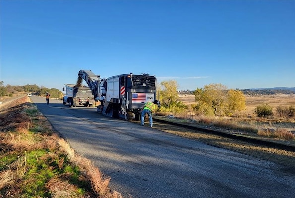 A large piece of construction machinery removes asphalt from the top of the levee at Folsom Dam's Dike 6 on December 2, 2024.