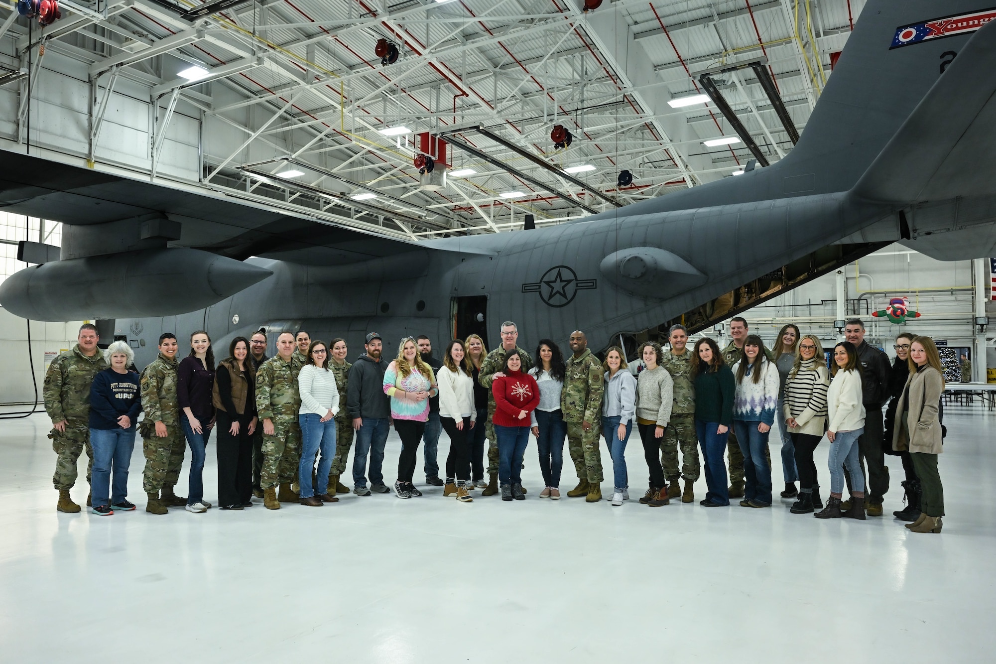 Airmen with the 910th Airlift Wing pose for a photo with their spouses prior to takeoff at Youngstown Air Reserve Station, Ohio, Dec. 7, 2024.