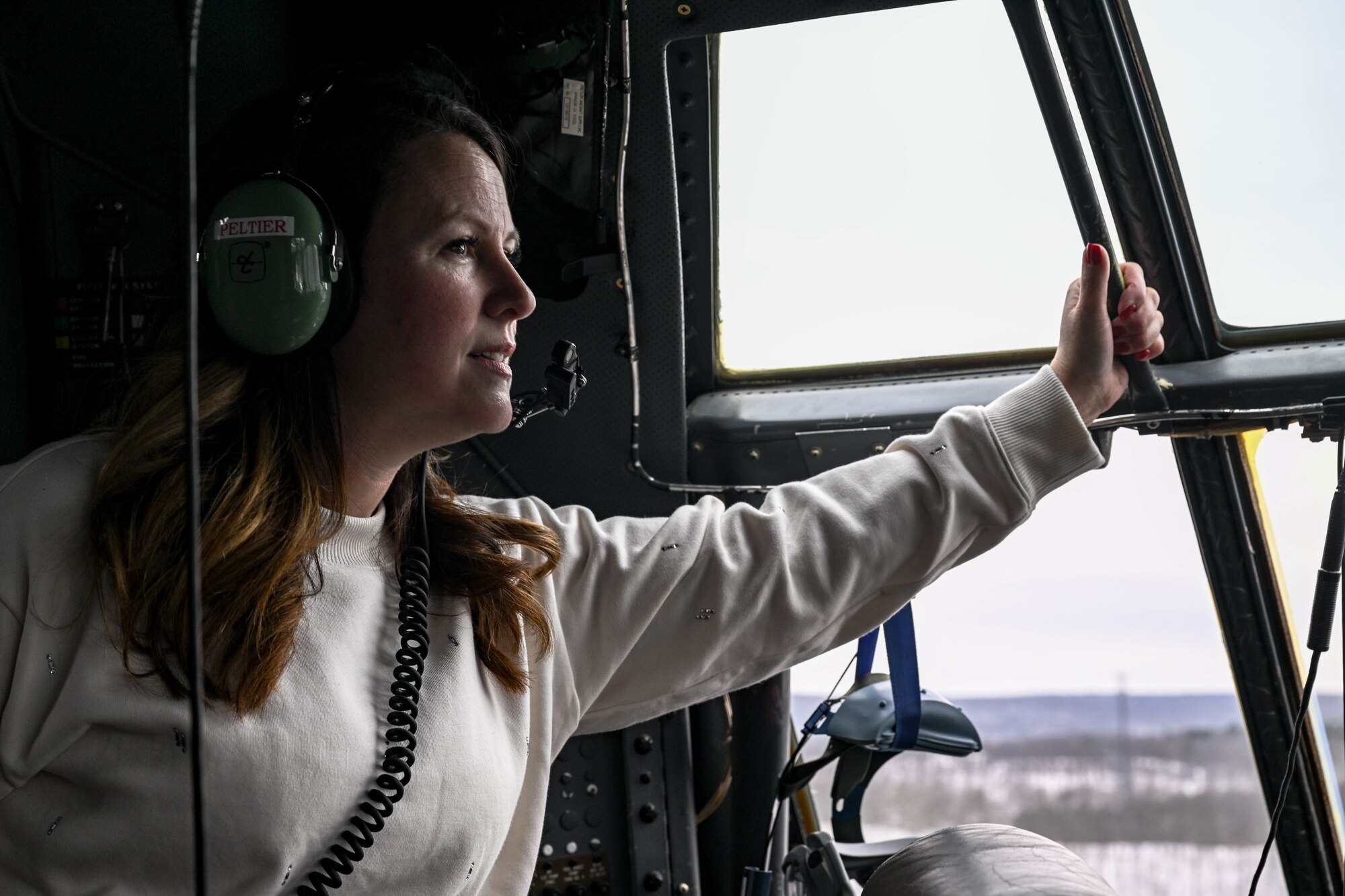 The spouse of a 910th Airlift Wing Airman looks out the flightdeck windows during an incentive flight, Dec. 7, 2024.