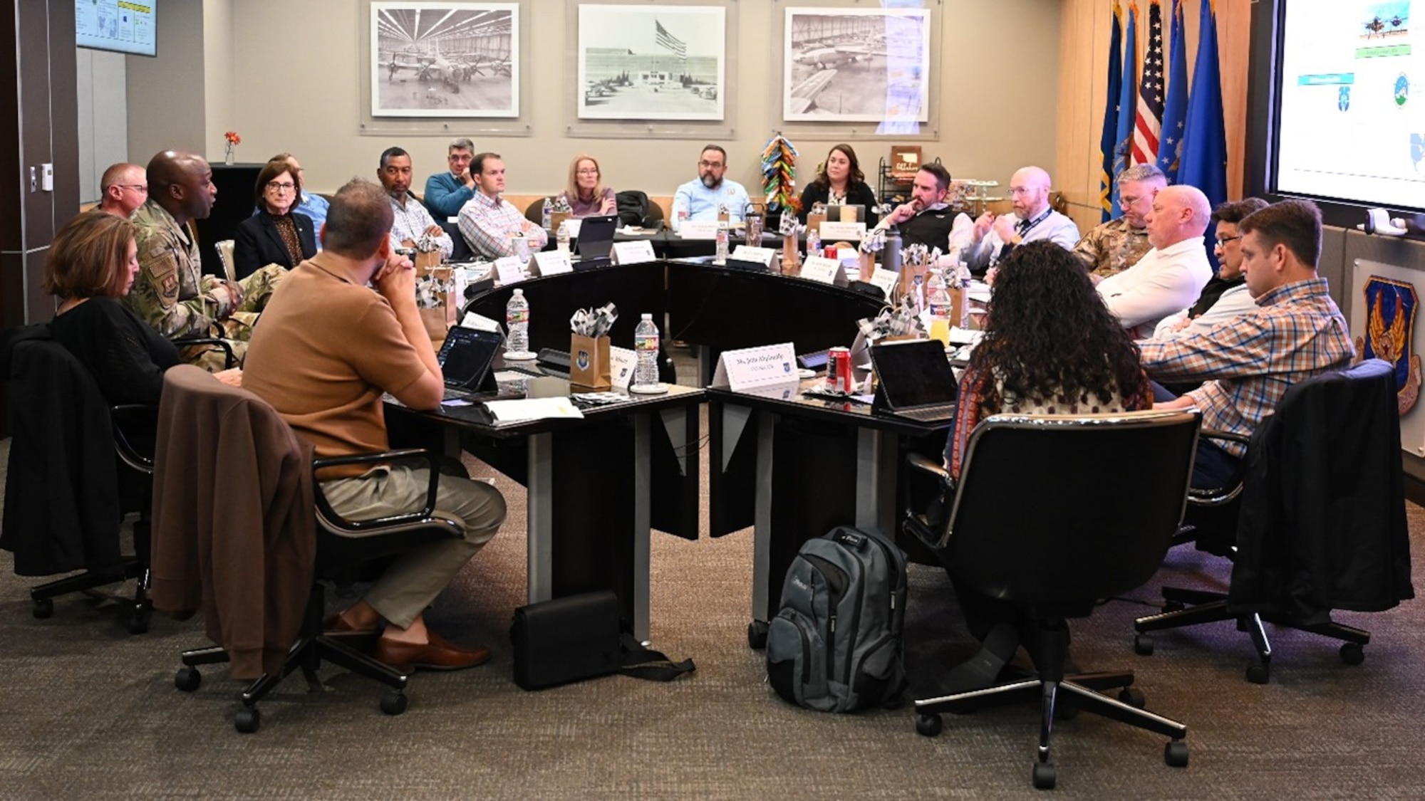 several men and women in sitting in a meeting