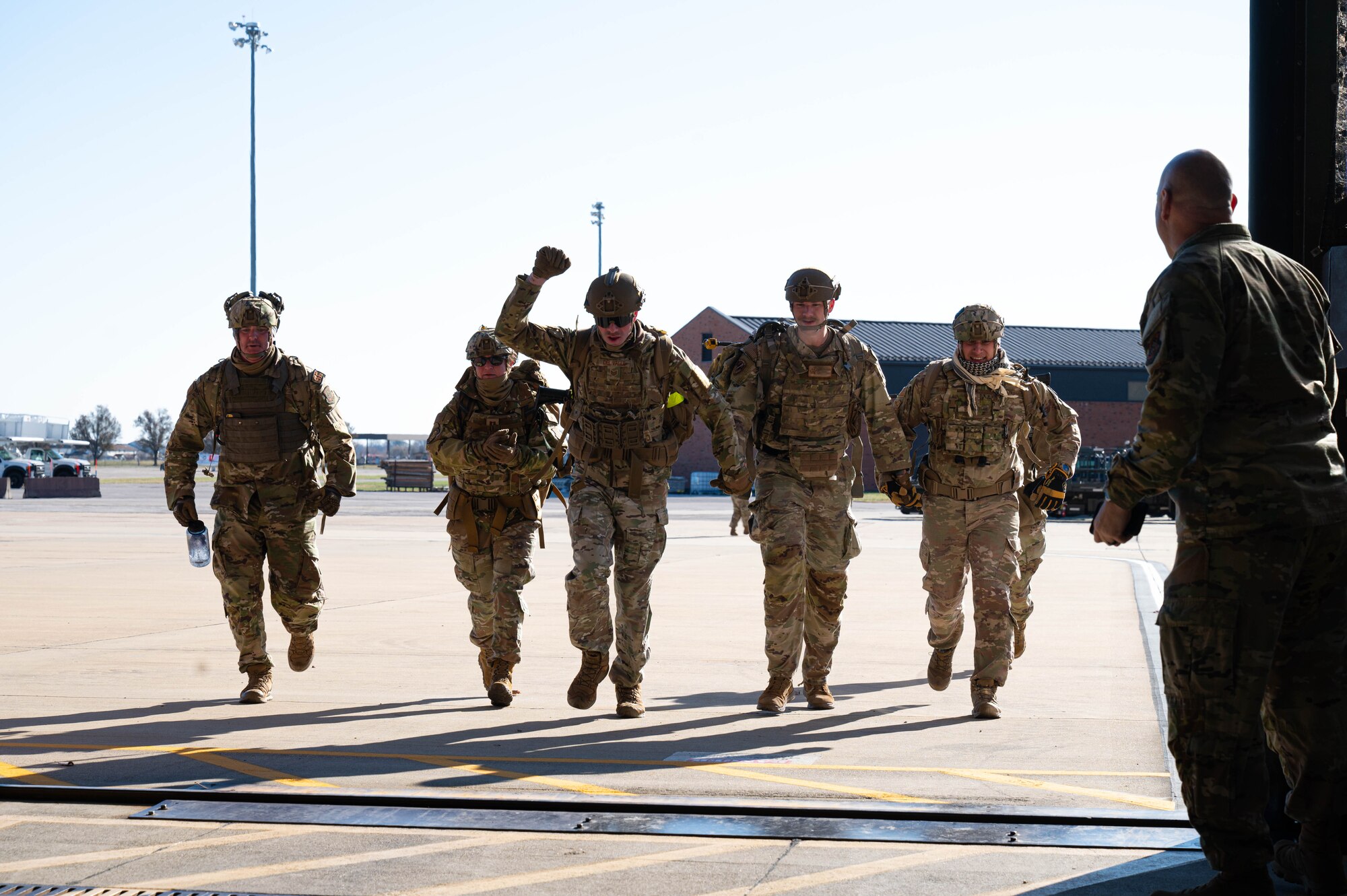 Airmen run into Air Force Hangar while being cheered on.