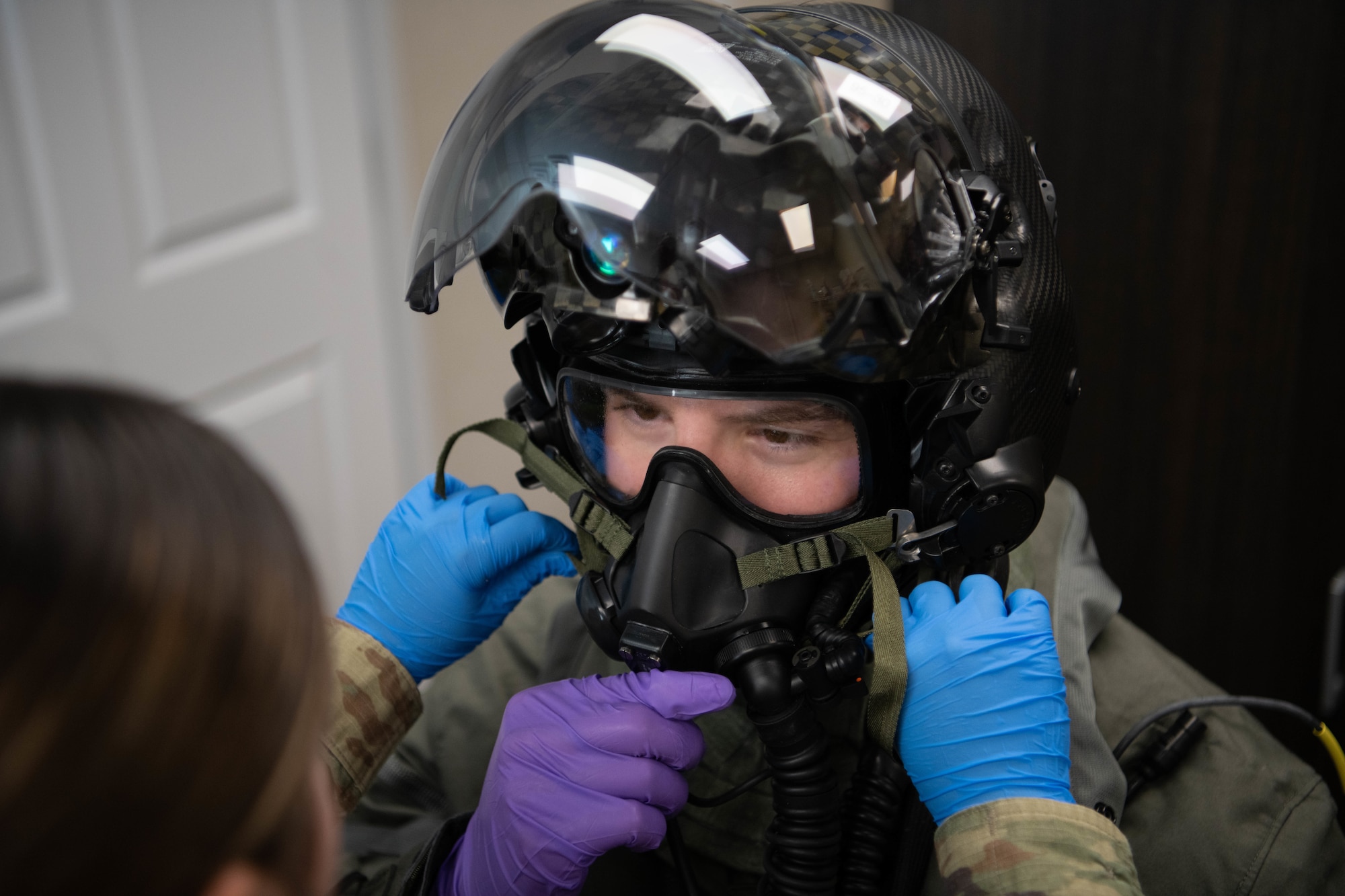 Pilot donning aircrew CBRN equipment