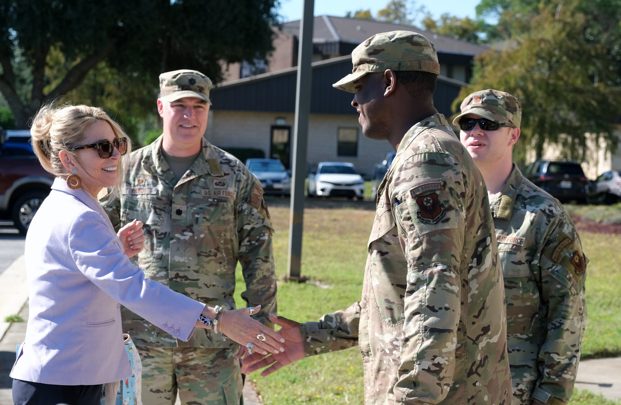 photo of uniformed U.S. Air Force Airman shaking hands with a civilian