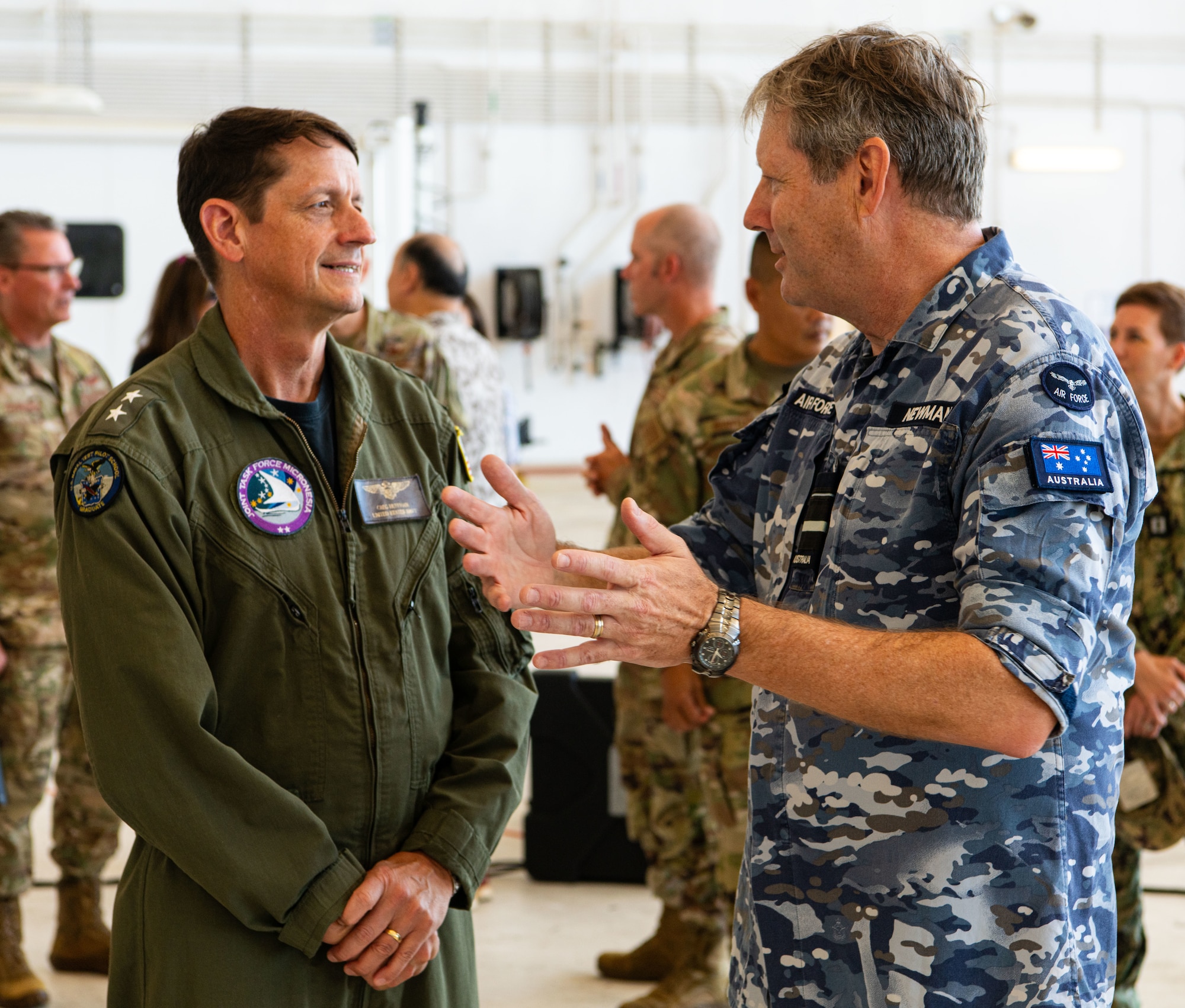 Air Vice-Marshal Carl Newman, the Pacific Air Forces deputy commander and the Deputy Theater Air Component Commander to the Commander, U.S. Indo-Pacific Command, speaks with Rear Admiral Gregory Huffman, commander of Joint Task Force - Micronesia, during the Operation Christmas Drop 2024 “Push Ceremony” at Andersen Air Force Base, Guam, Dec. 9, 2024.