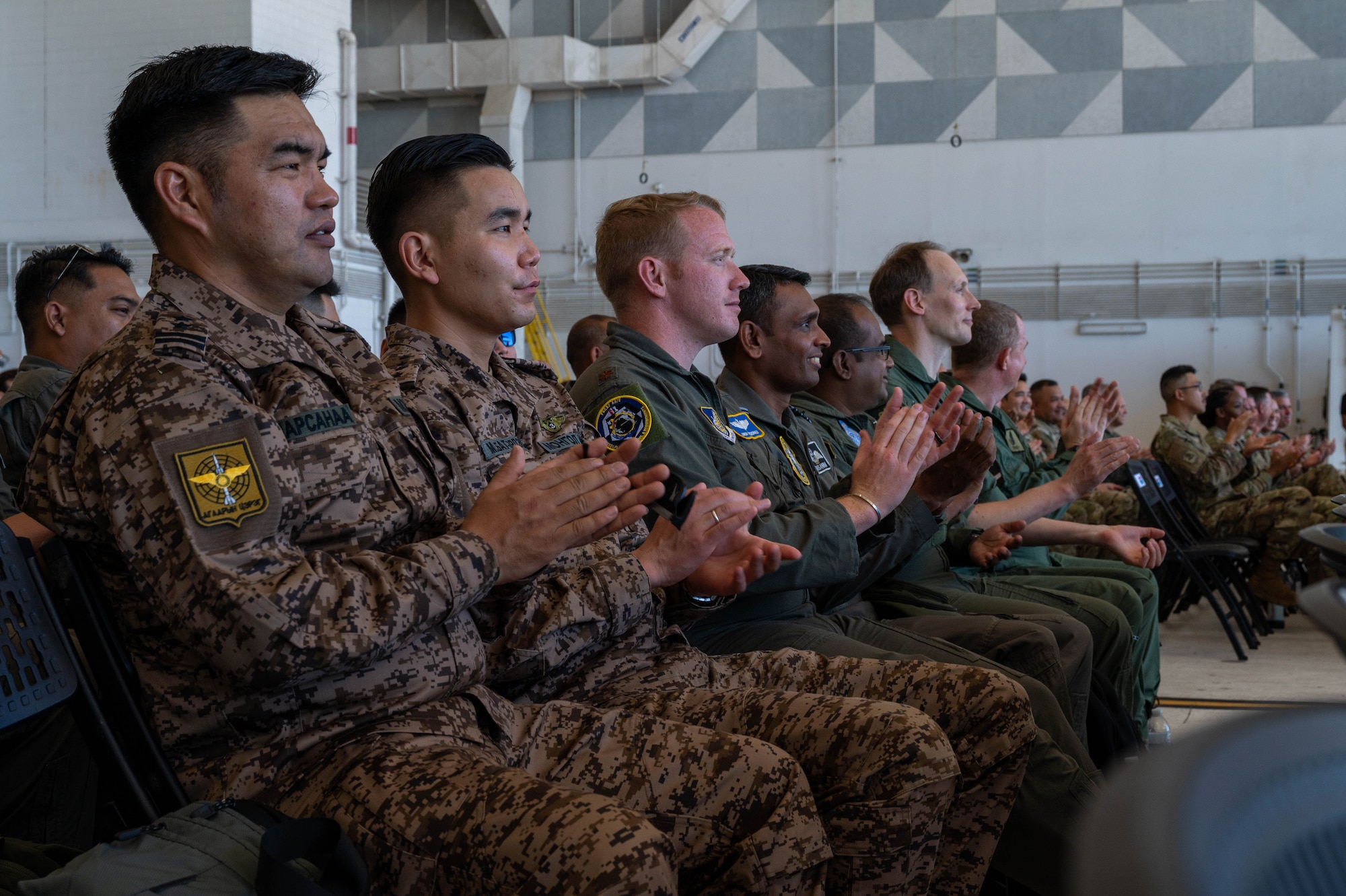 International guests applaud while attending the Operation Christmas Drop push ceremony at Andersen Air Force Base, Guam, Dec. 9, 2024.