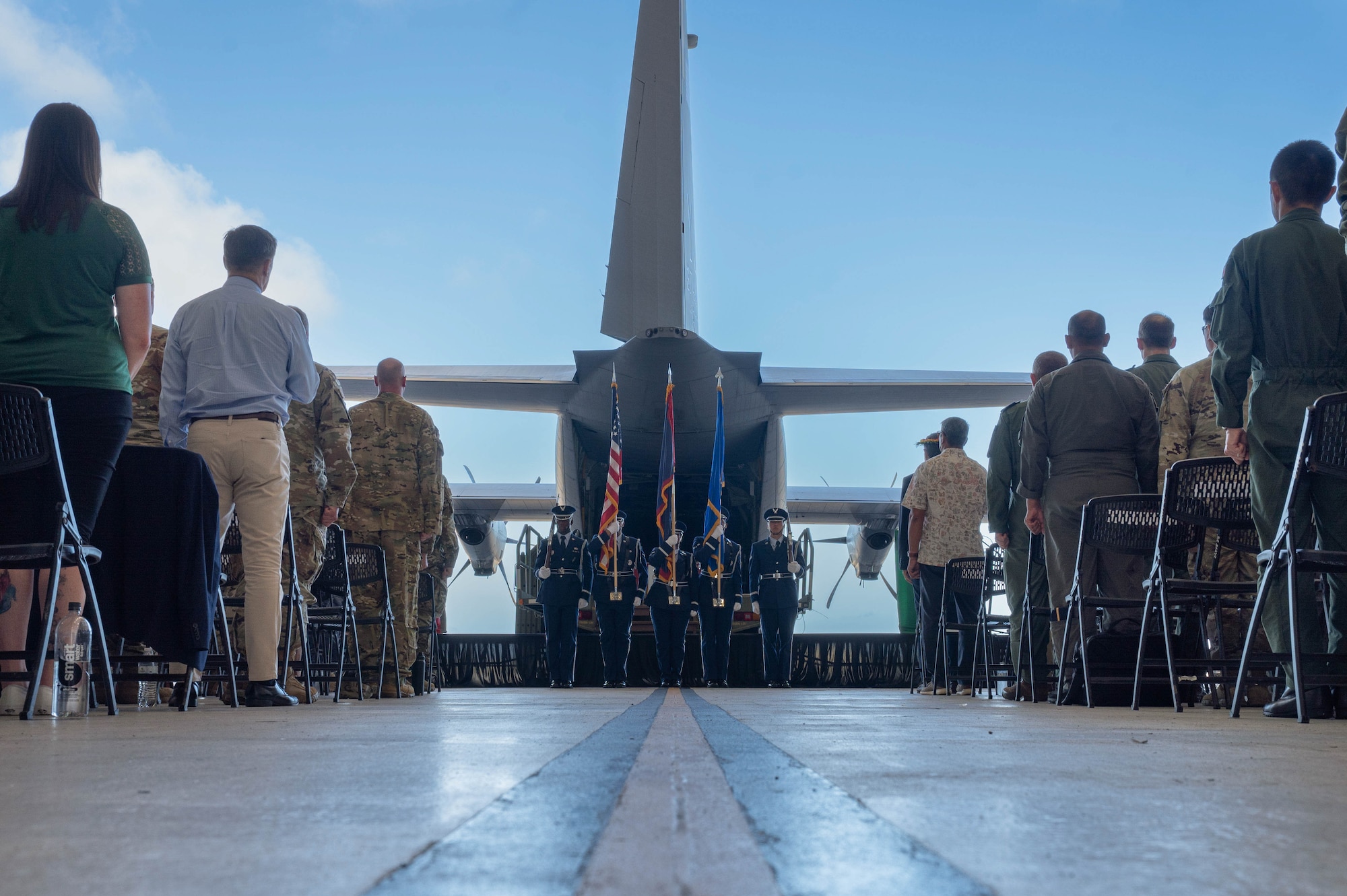 Guests attending the Operation Christmas Drop push ceremony stand for the U.S. national anthem at Andersen Air Force Base, Guam, Dec. 9, 2024.