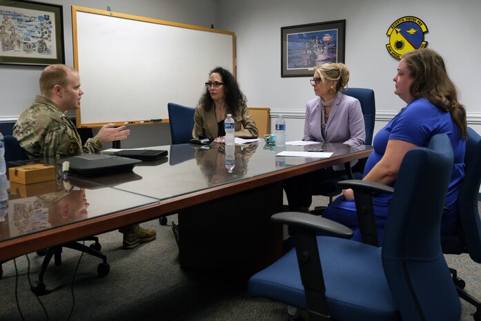 photo of civilians and U.S. Air Force Airmen sitting at a table