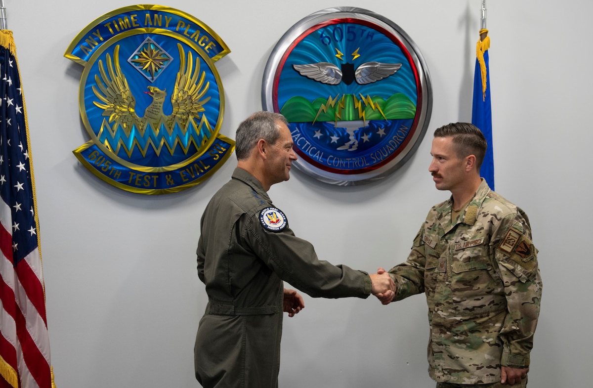 photo of two uniformed U.S. Air Force Airmen shaking hands