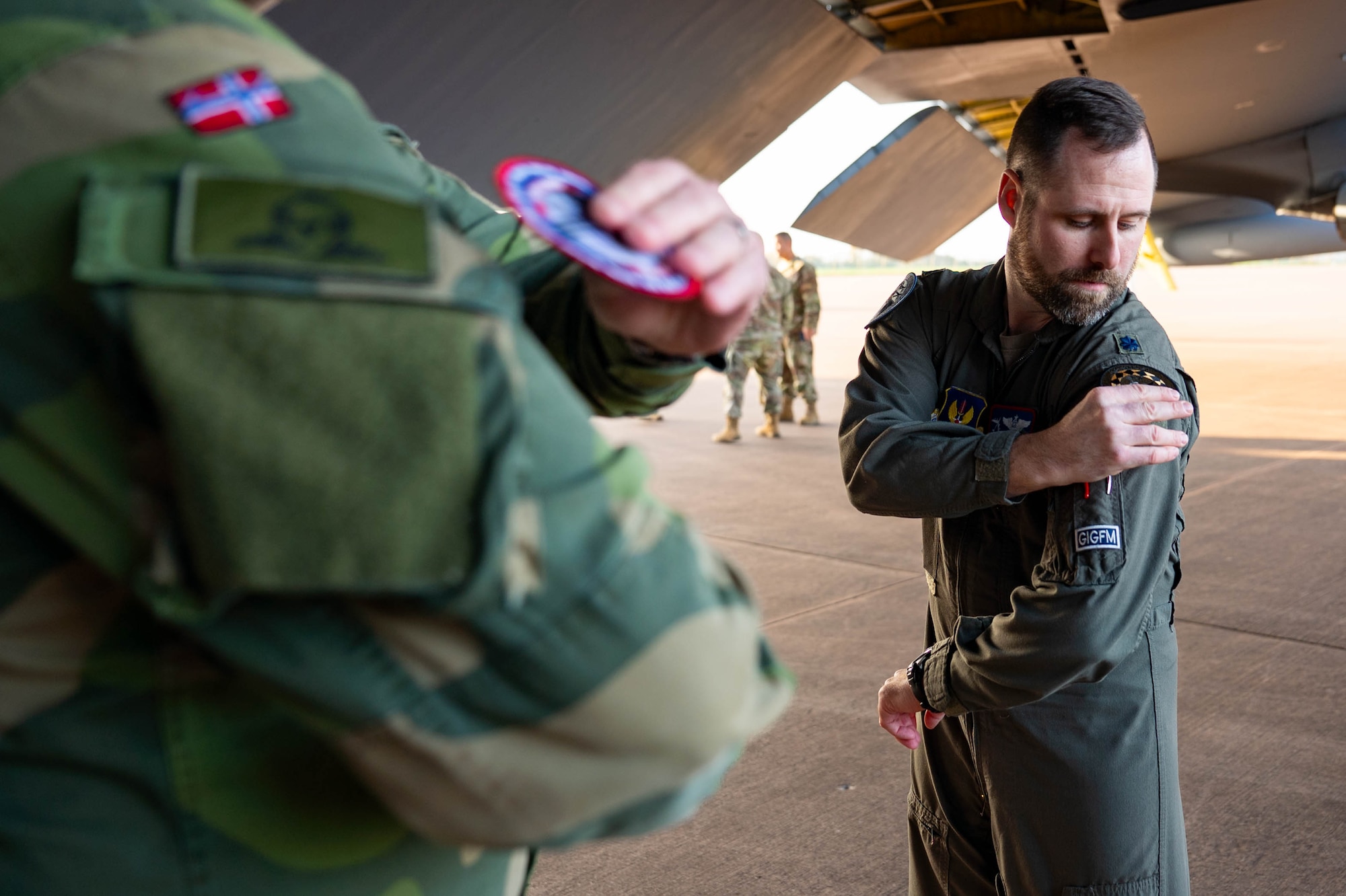 U.S. Air Force Lt. Col. Kendall Smith, 603rd Air Operation Center chief of Bomber Task Force USAFE-AFAFRICA, swaps patches with a member of the Royal Norwegian Air Force during Bomber Task Force 25-1, at RAF Fairford, England, Nov. 13, 2024. United with NATO partners, the U.S. reinforces its commitment to deter threats and maintain stability throughout Europe. (U.S. Air Force photo by Senior Airman Mary Bowers)