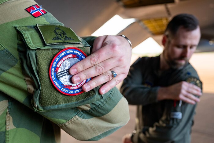 U.S. Air Force Lt. Col. Kendall Smith, 603rd Air Operation Center chief of Bomber Task Force USAFE-AFAFRICA, swaps patches with a member of the Royal Norwegian Air Force during Bomber Task Force 25-1, at RAF Fairford, England, Nov. 13, 2024. Our dedication to peace and stability in Europe remains unshaken. The U.S. will continue to partner with Allies to deter threats and protect the sovereignty of nations throughout the region. (U.S. Air Force photo by Senior Airman Mary Bowers)