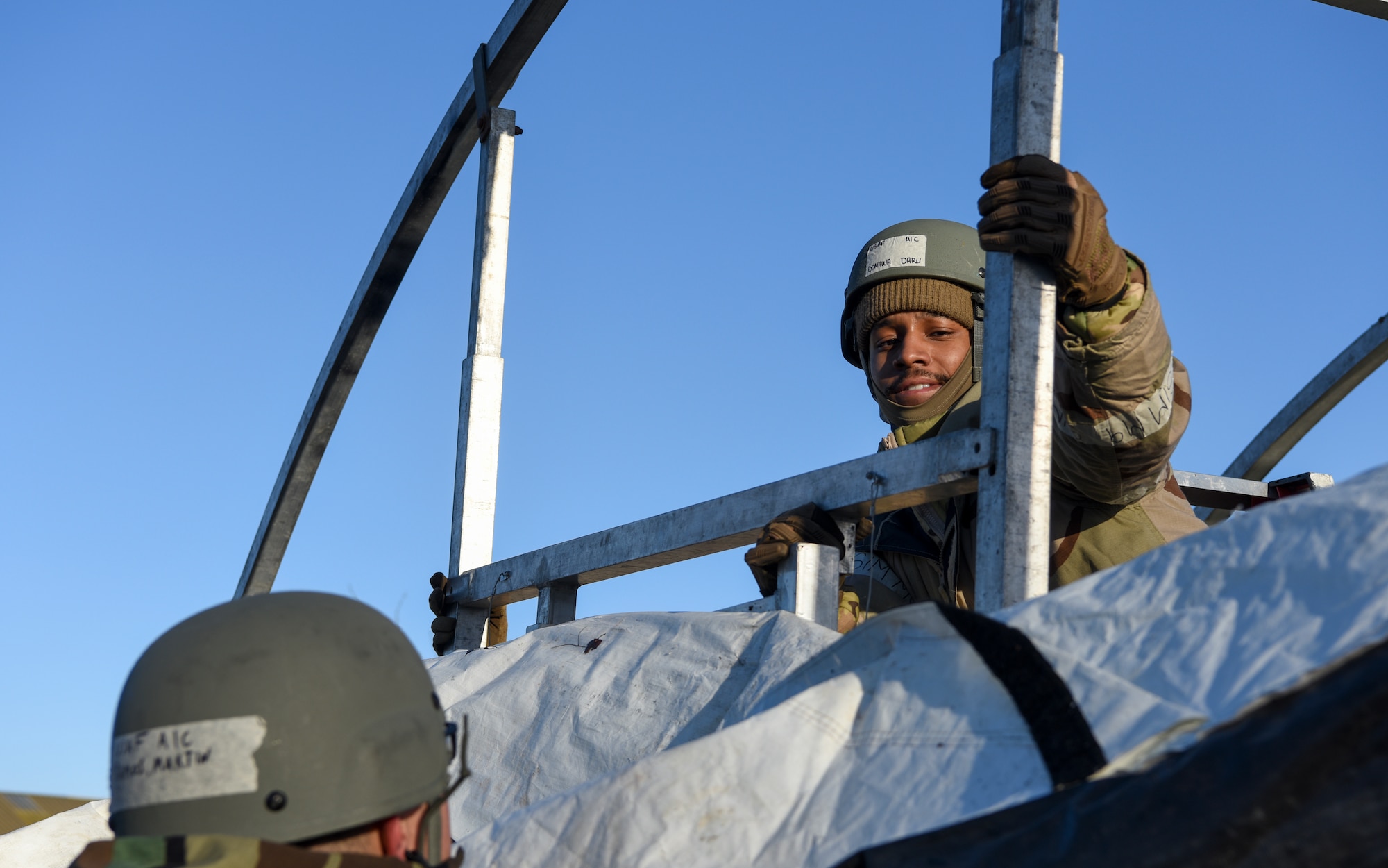 U.S. Air Force Airman 1st Class Daru Donawa, 100th Civil Engineer Squadron firefighter, puts a part of a tent frame into place during a Prime Base Engineer Emergency Force (Prime BEEF) readiness day at Royal Air Force Mildenhall, England, Nov. 21, 2024.