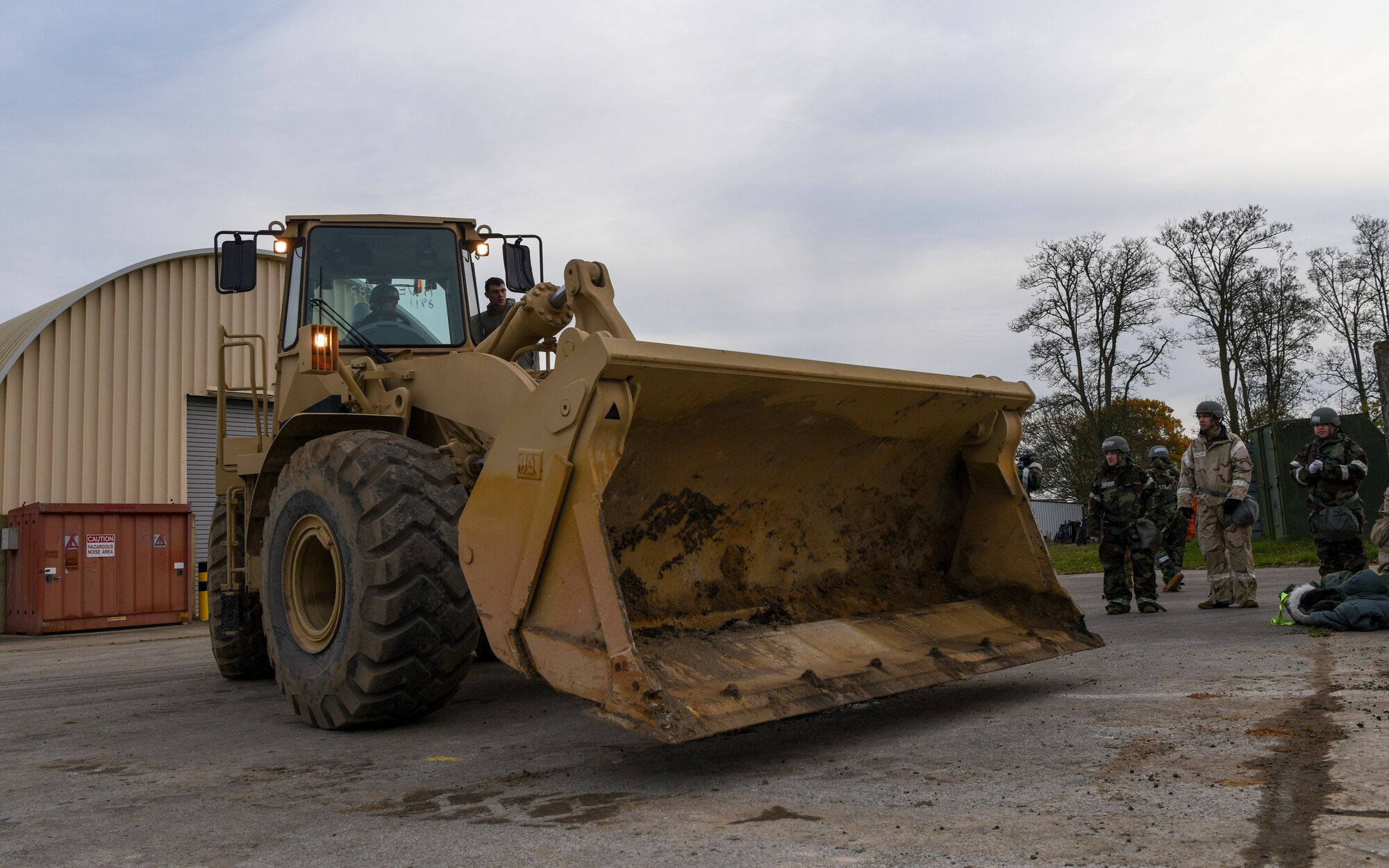 U.S. Air Force Senior Airman Jeb Laurenson, center, 100th Civil Engineer Squadron pavement and equipment journeyman, instructs another 100th CES Airman on operating a wheel loader during a Prime Base Engineer Emergency Force (Prime BEEF) readiness day at Royal Air Force Mildenhall, England, Nov. 21, 2024.