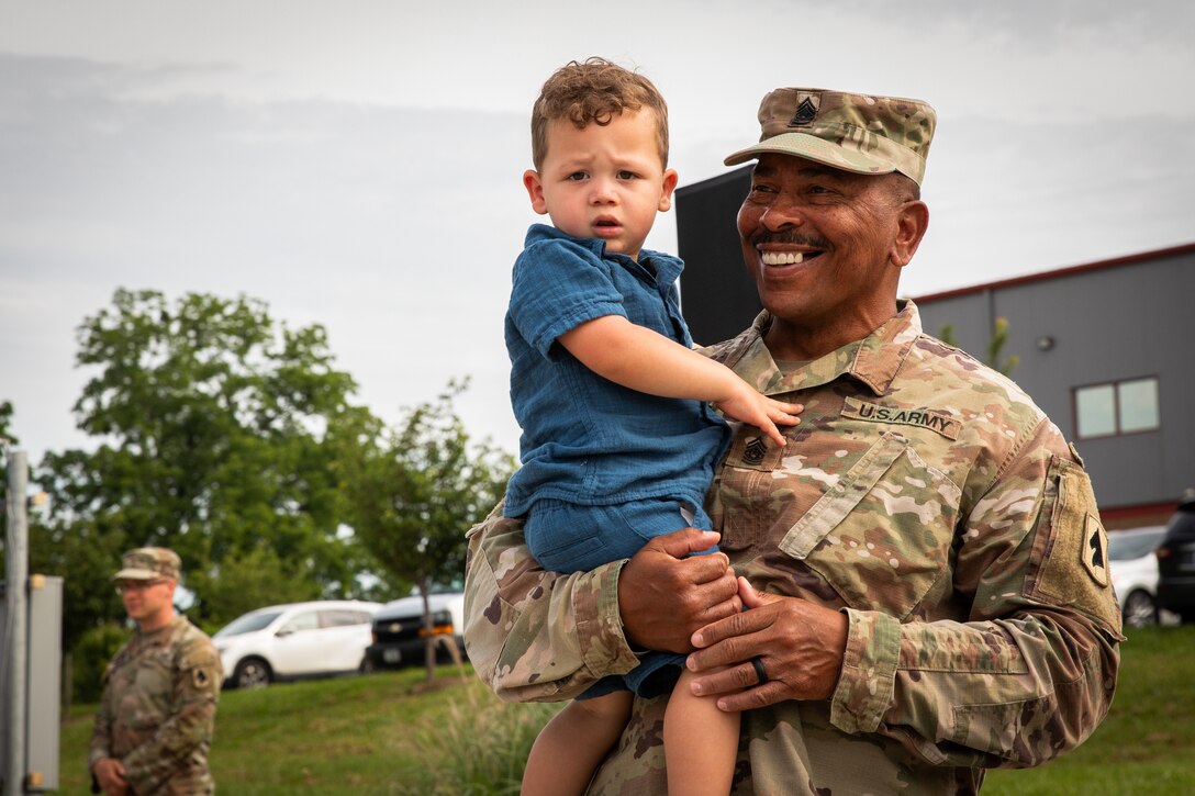 Command Sgt. Maj. Robert C. Render, 103rd Brigade Support Battalion holds his grandson at his retirement in Harrodsburg, Kentucky on June 14, 2024. Render is retiring from the Kentucky Army National Guard with 43 years, and 10 months; he is longest serving member of the Kentucky National Guard. (U.S. Army National Guard photo by Sgt. 1st Class Andrew Dickson)