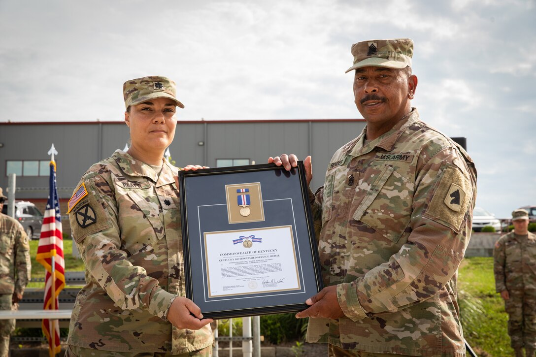 Command Sgt. Maj. Robert C. Render, 103rd Brigade Support Battalion, is presented the Kentucky Distinguished Service Medal from Lt. Col. Esther Platt at his retirement ceremony in Harrodsburg, Kentucky on June 14, 2024. Render is retiring from the Kentucky Army National Guard with 43 years, and 10 months; he is longest serving member of the Kentucky National Guard. (U.S. Army National Guard photo by Sgt. 1st Class Andrew Dickson)