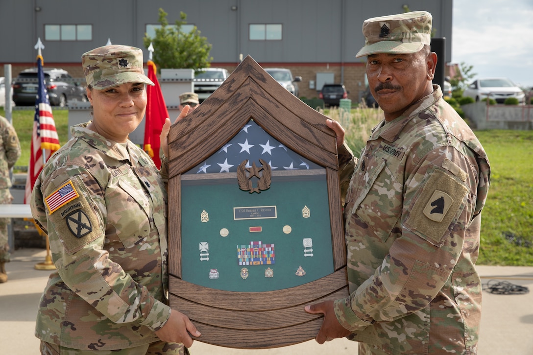 Command Sgt. Maj. Robert C. Render, 103rd Brigade Support Battalion, is presented a shadow box from Lt. Col. Esther Platt at his retirement ceremony in Harrodsburg, Kentucky on June 14, 2024. Render is retiring from the Kentucky Army National Guard with 43 years, and 10 months; he is longest serving member of the Kentucky National Guard. (U.S. Army National Guard photo by Sgt. 1st Class Andrew Dickson)